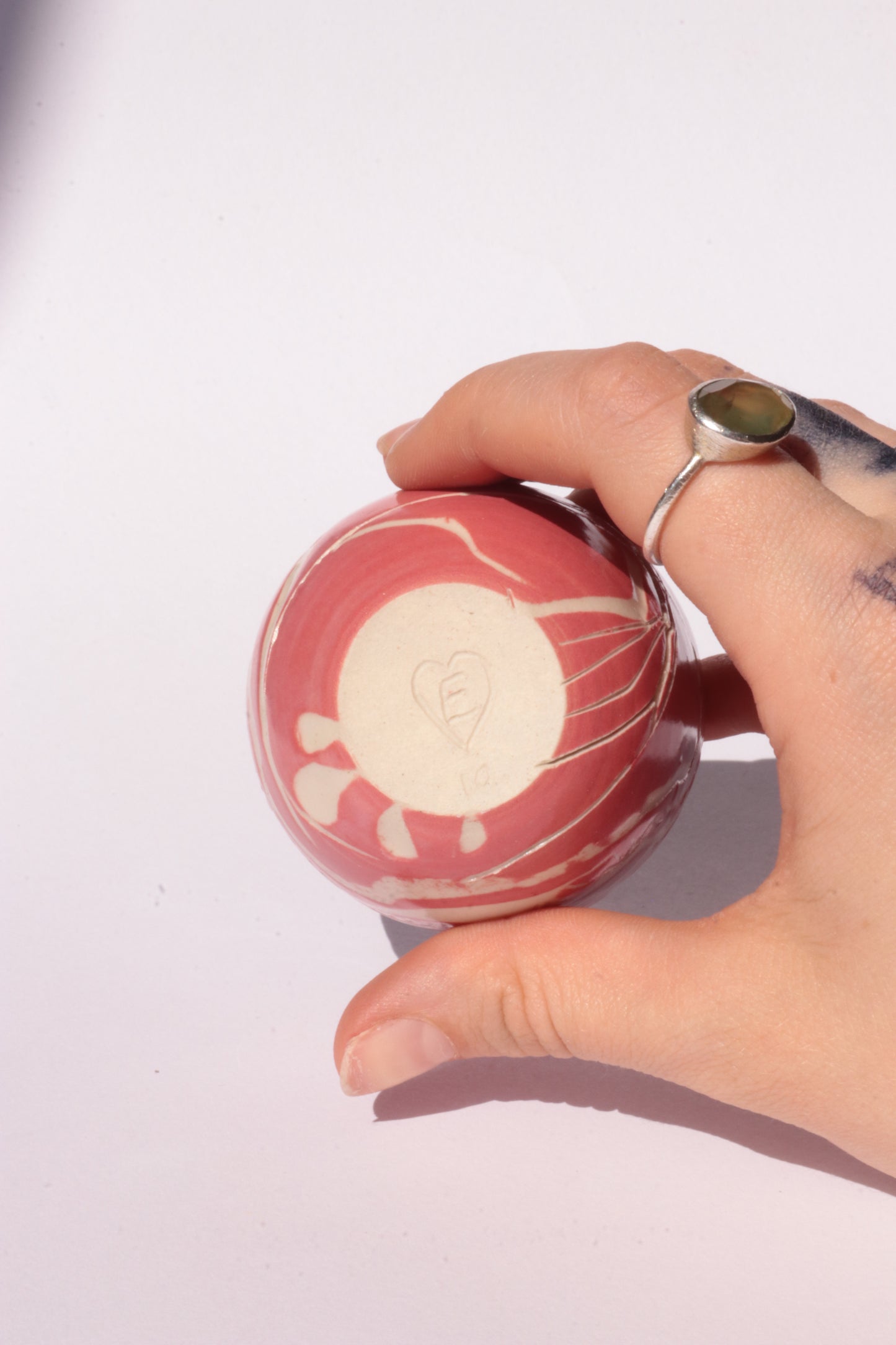 engraved magenta ceramic cup on white background