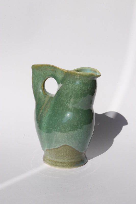Green ceramic jog with integrated handle and spout