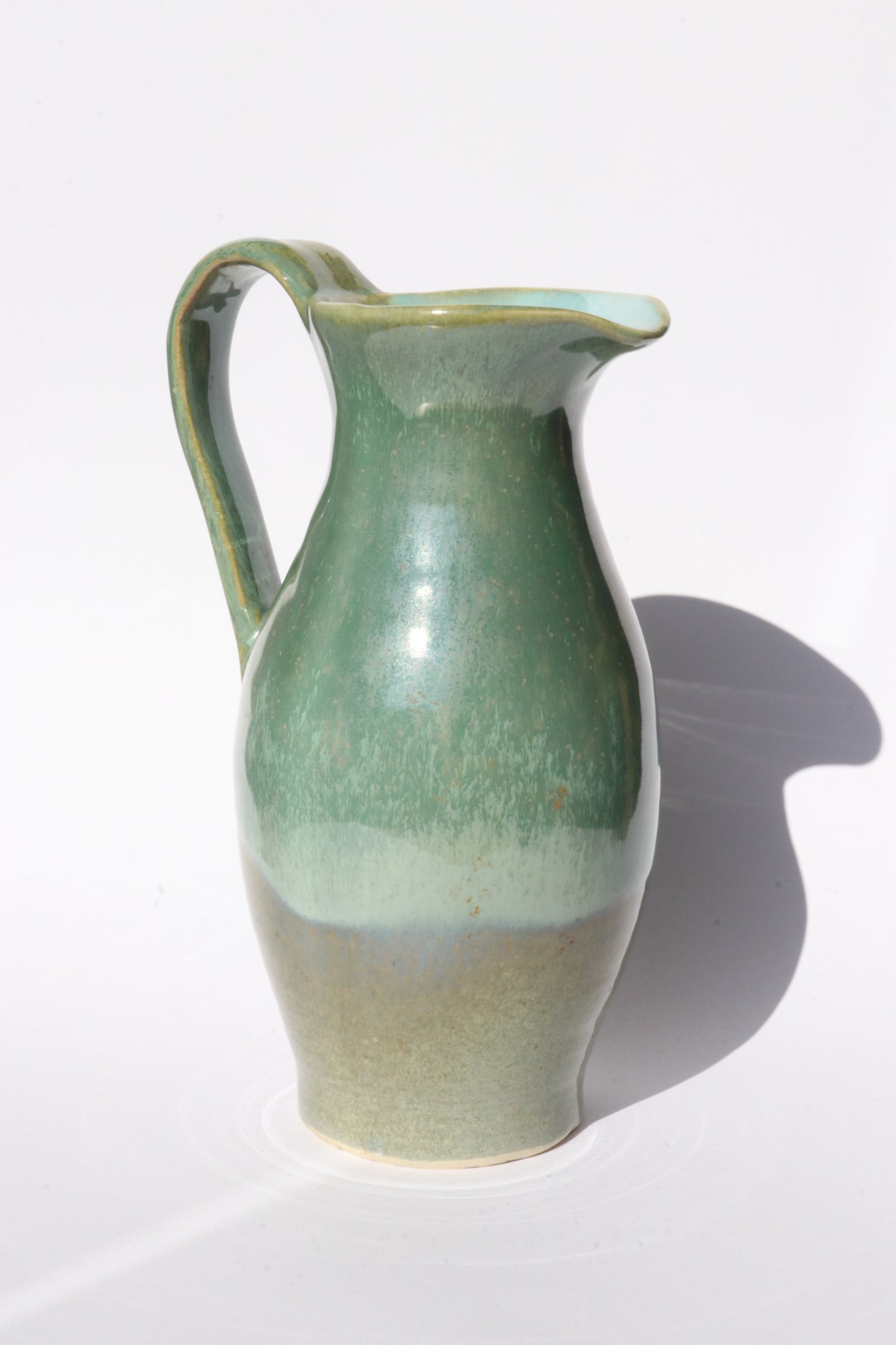 Green ceramic jug on white background
