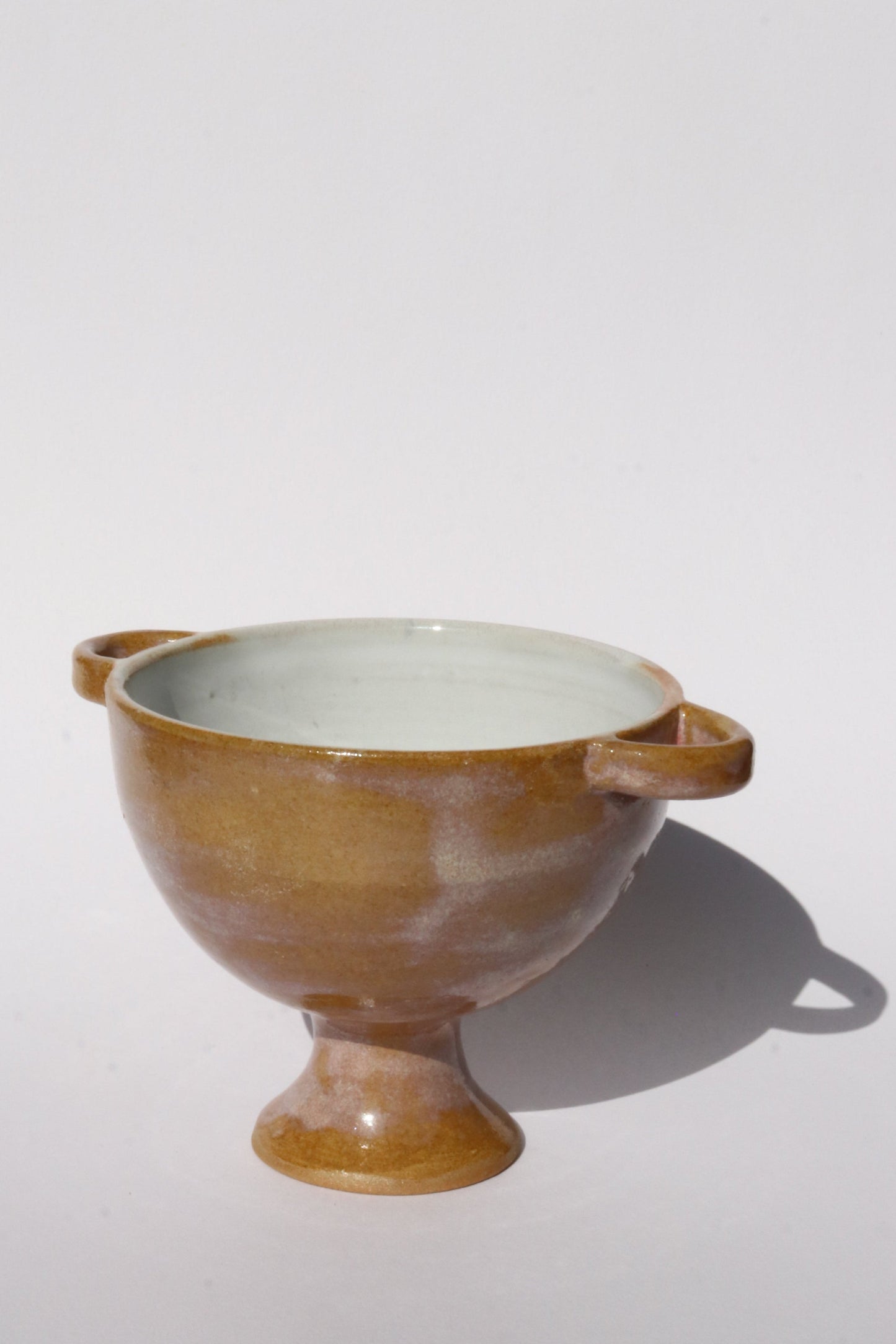 Ceramic bowl with brown and white design on a light gray background