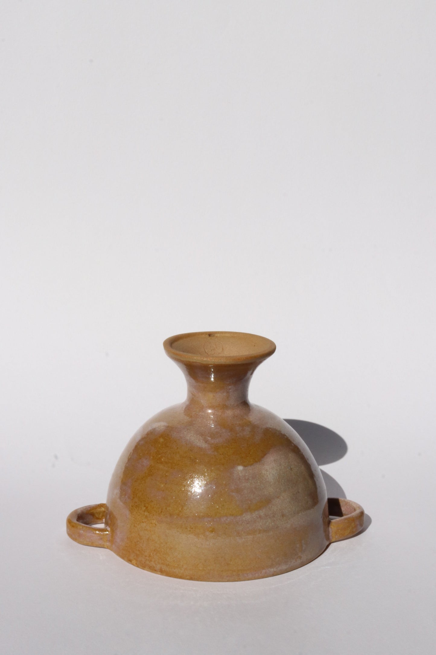 Brown ceramic footed bowl on a white background
