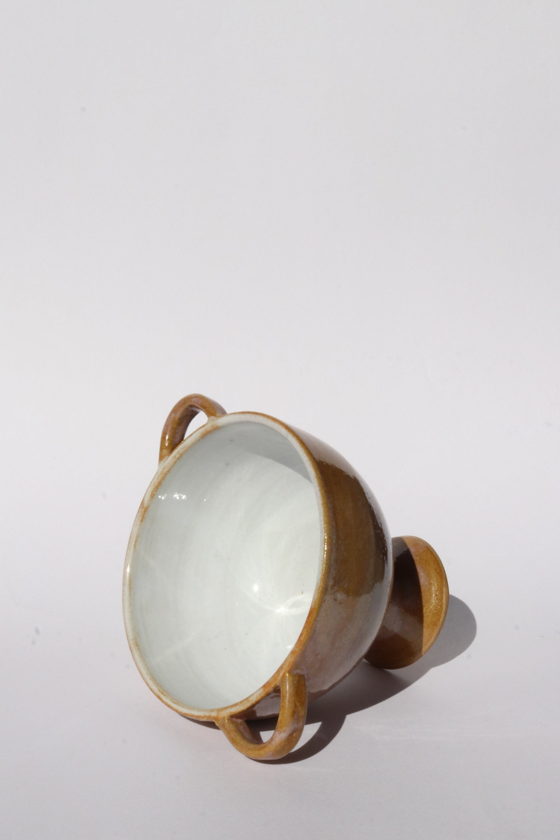 Ceramic bowl with handles on a white background