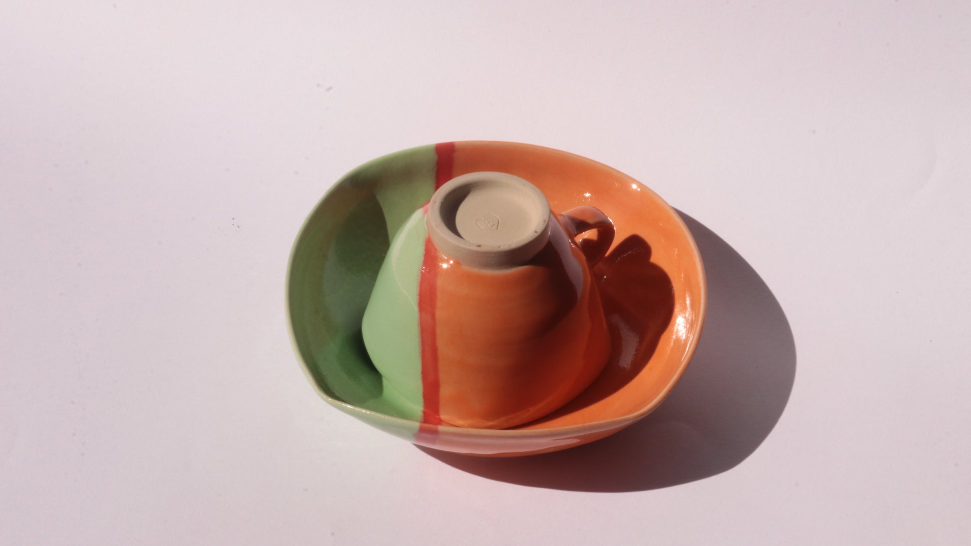Ceramic cup and saucer with a colorful design on a white background