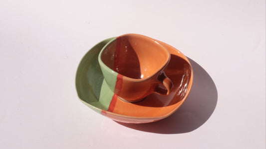 colourful ceramic cup and saucer on white background