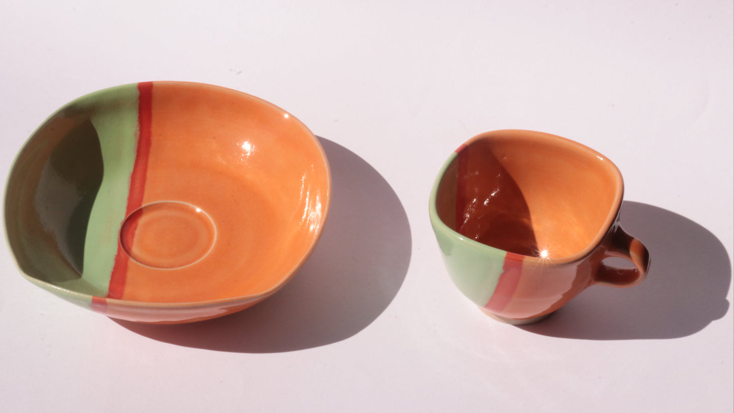 Ceramic bowl and cup with multicolored design on a white background