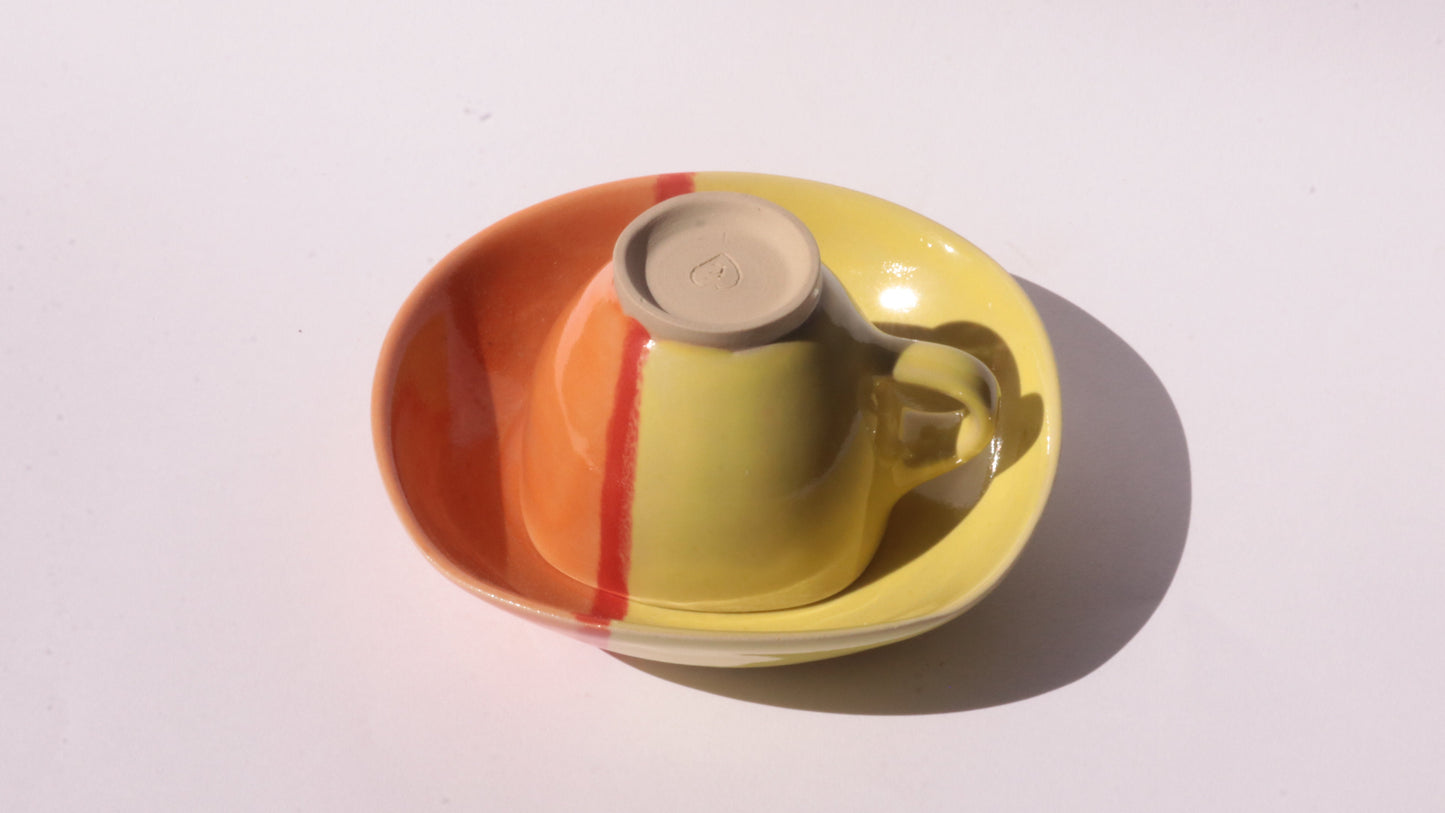 Colorful ceramic cup and saucer on a white background