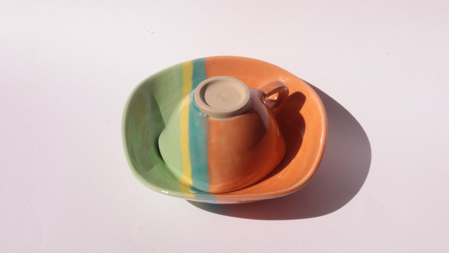 colourful ceramic cup and saucer on white background