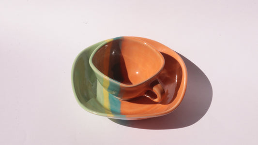 Colorful ceramic cup and saucer on a white background