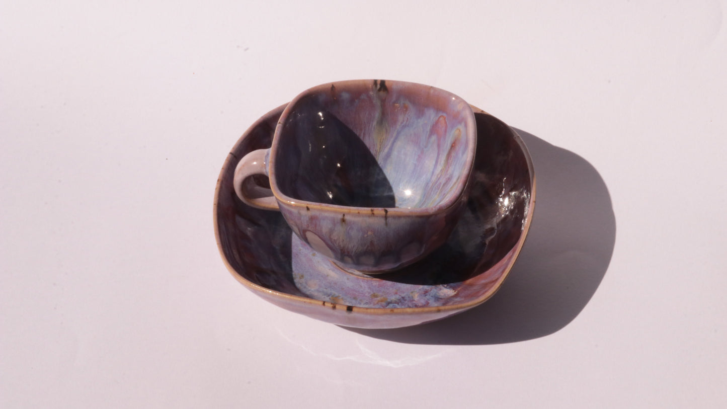 purple coffee cup and saucer with square rims on white background