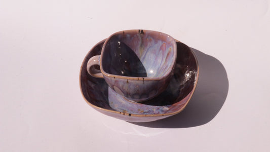 purple coffee cup and saucer with square rims on white background
