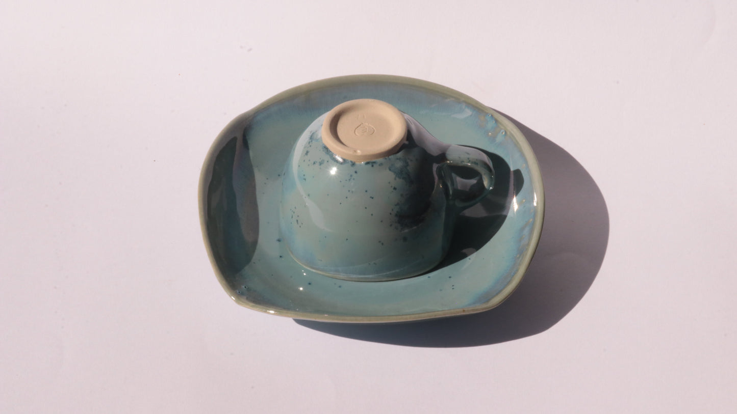 Blue coffee cup and saucer with square rims on white background