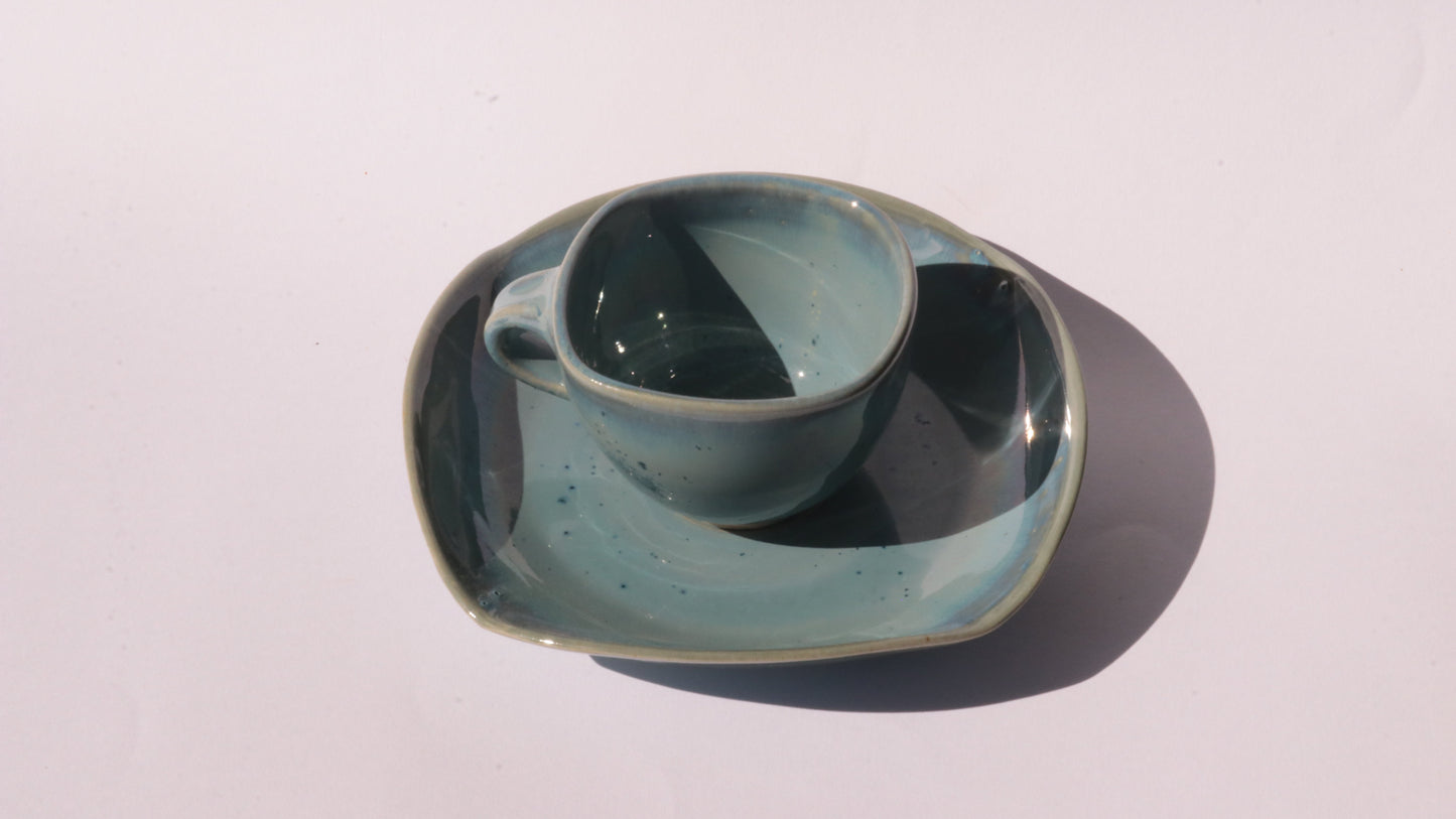 Blue coffee cup and saucer with square rims on white background