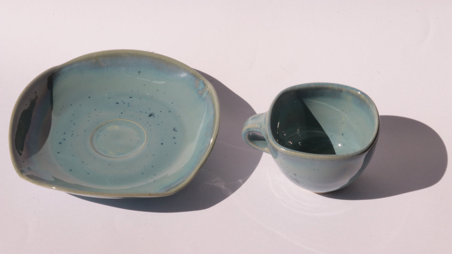 Blue coffee cup and saucer with square rims on white background