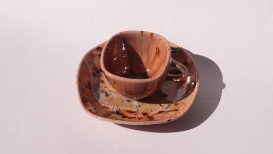 Orange and Pink coffee cup and saucer with square rims on white background