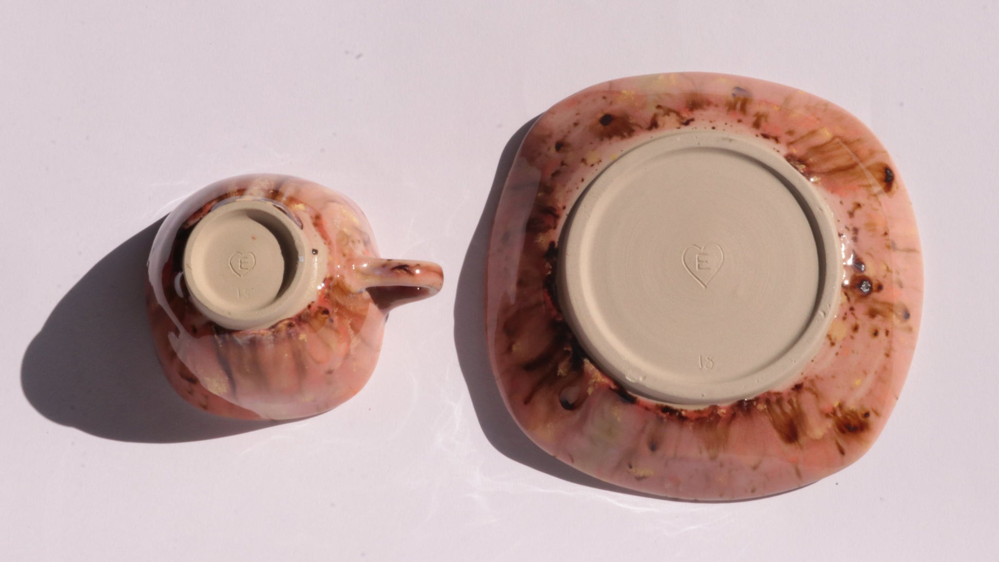 Orange and Pink coffee cup and saucer with square rims on white background