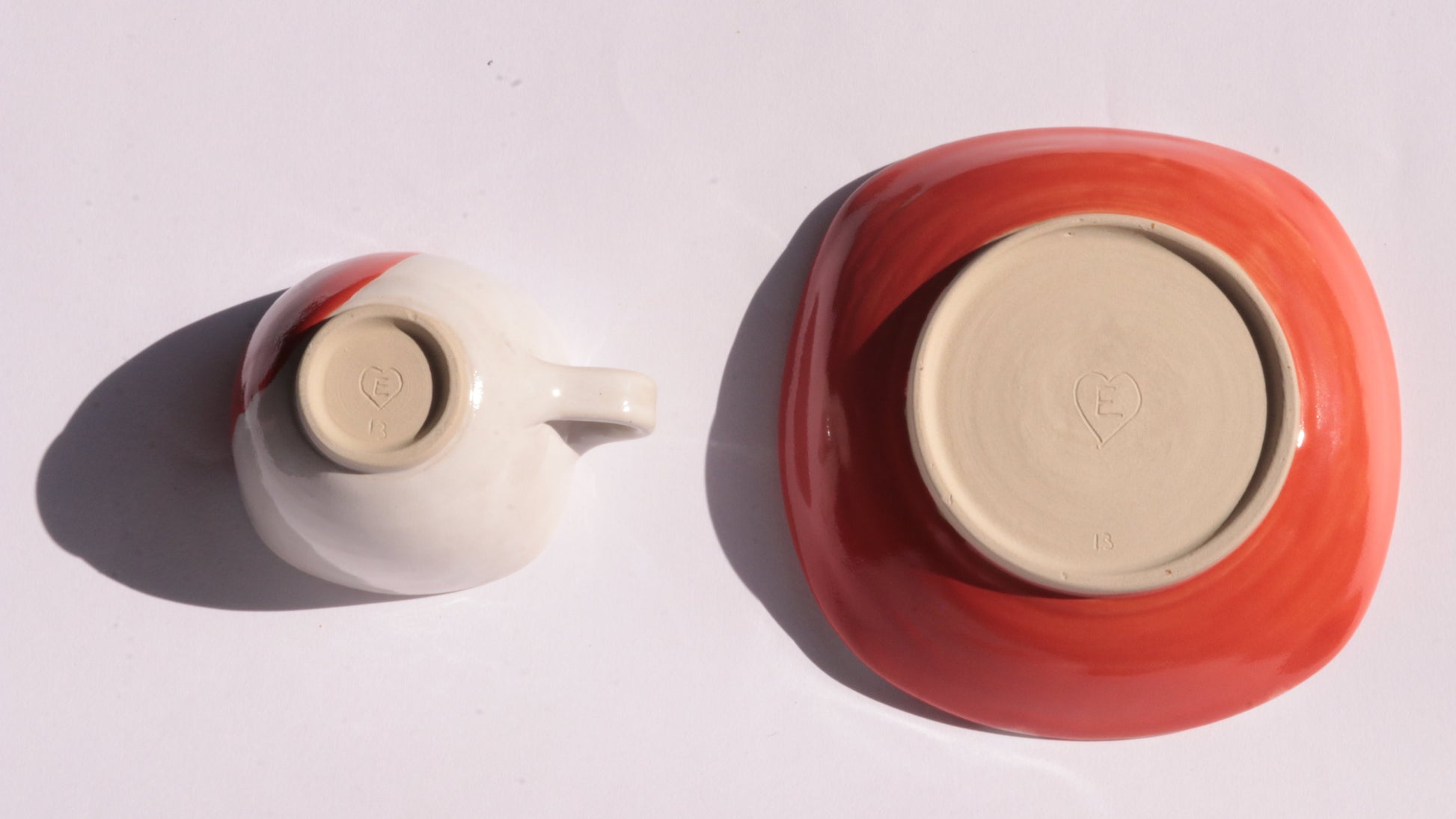Ceramic cup and saucer with red and white stripes on a white background