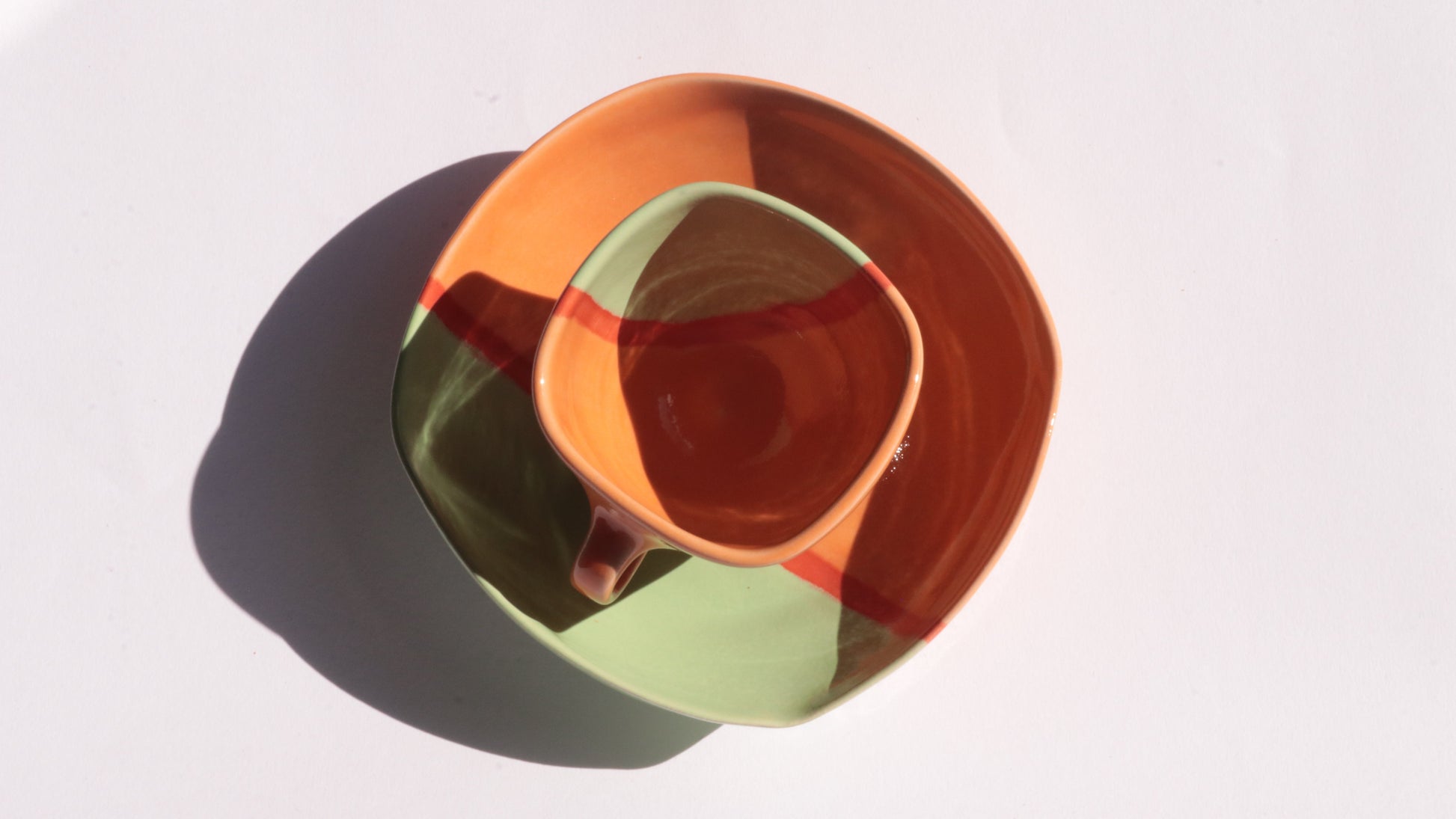Stack of colorful ceramic cup and plate on a white background