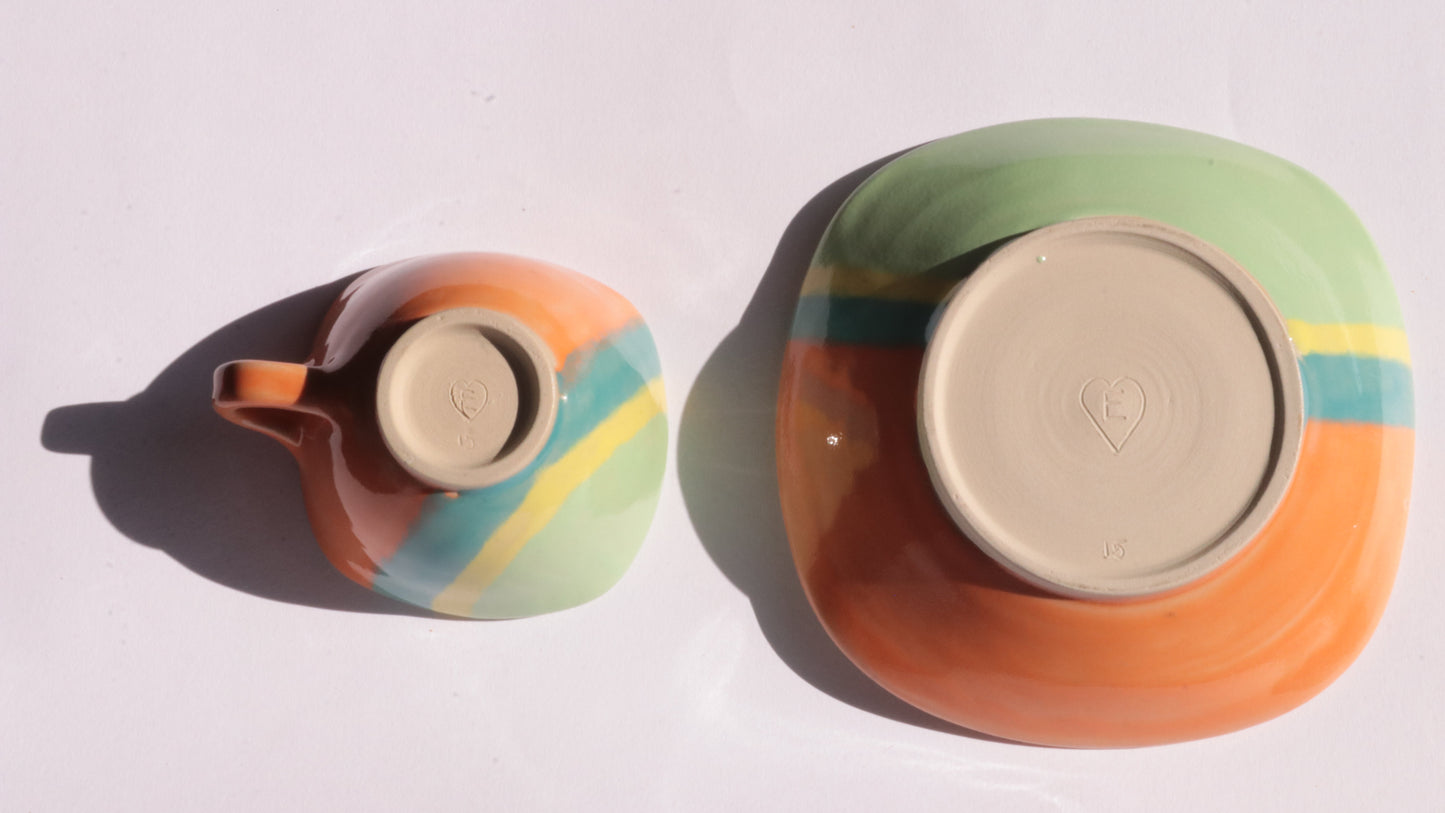 ceramic cup and plate with colorful stripes on a white background