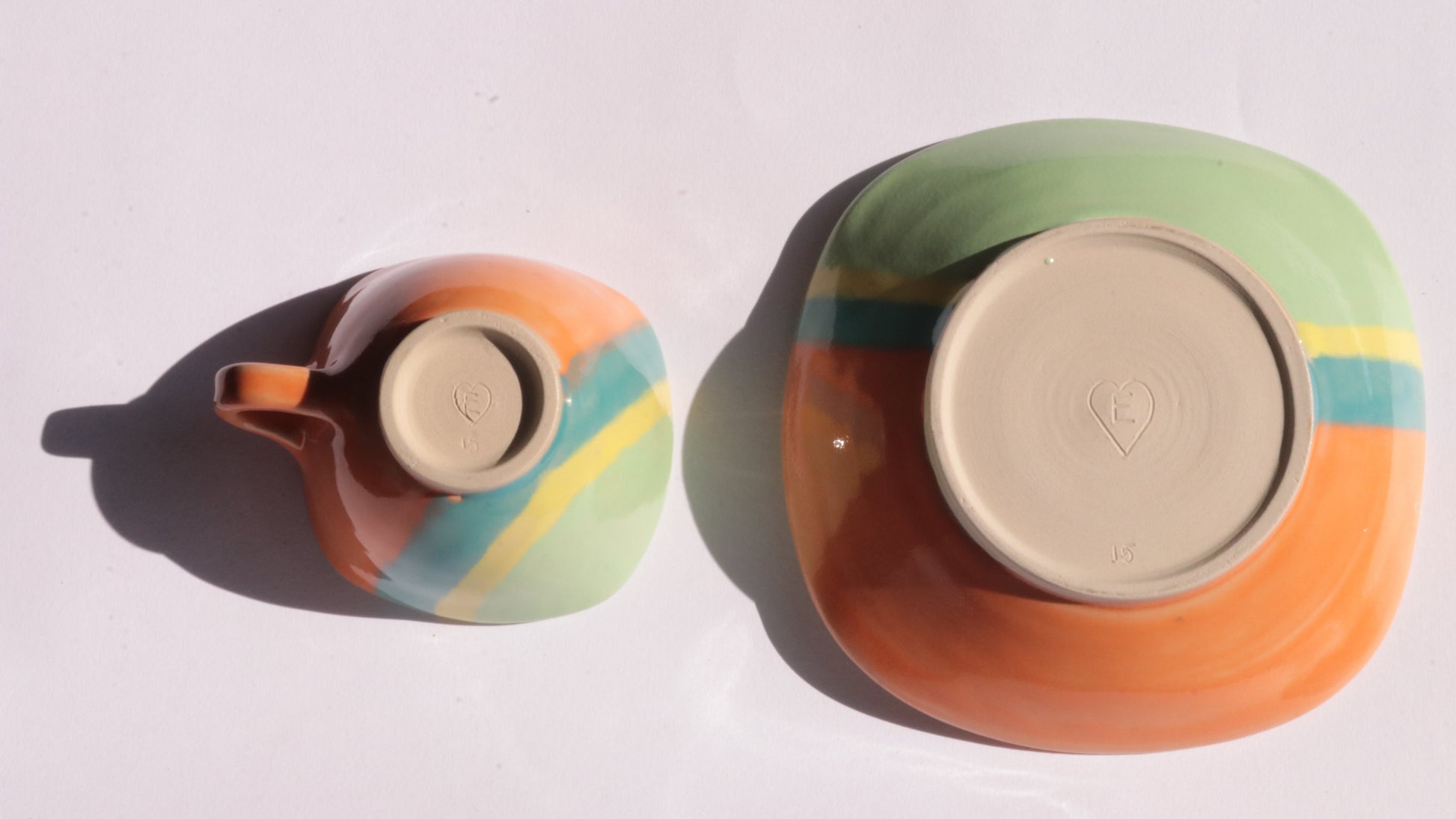 ceramic cup and plate with colorful stripes on a white background