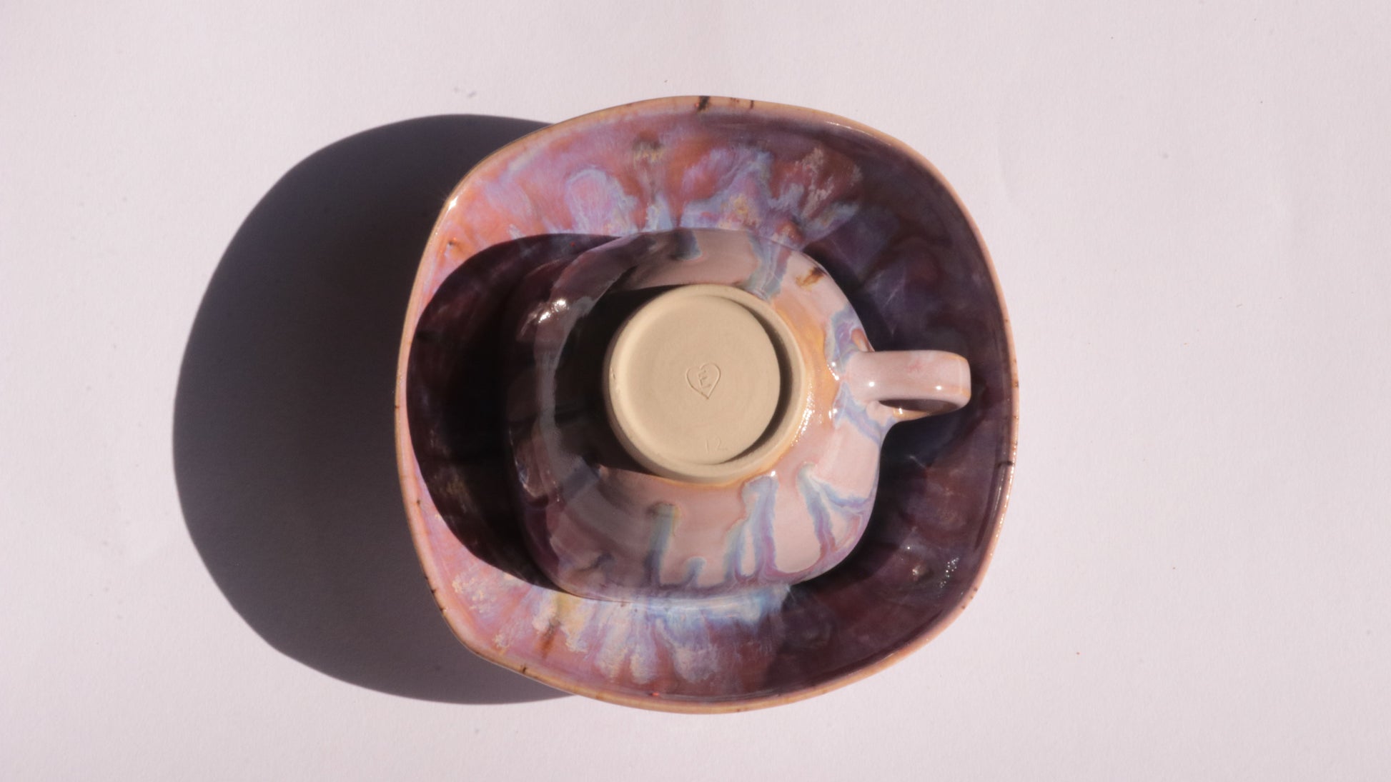 purple coffee cup and saucer with square rims on white background