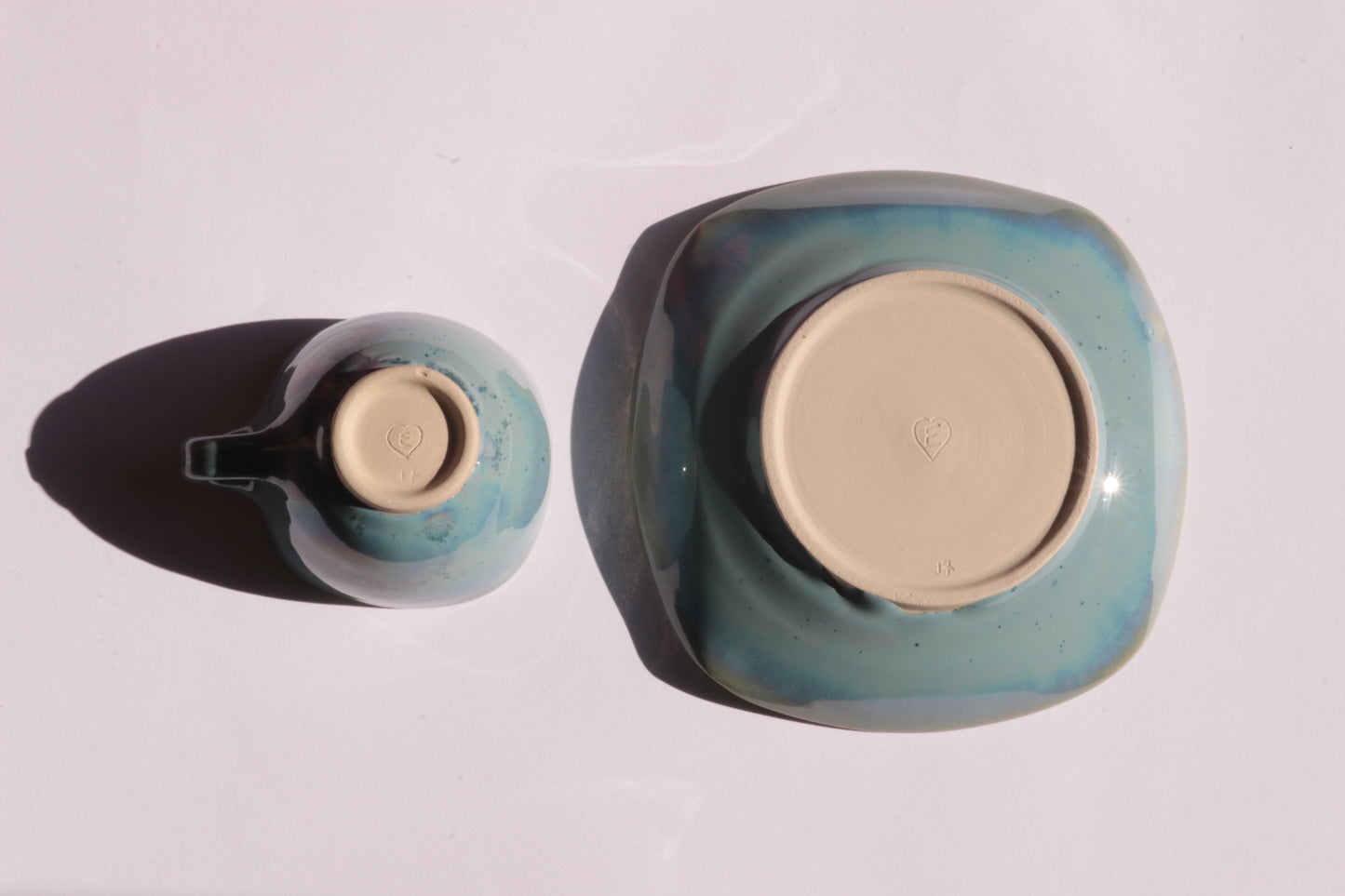 Blue coffee cup and saucer with square rims on white background