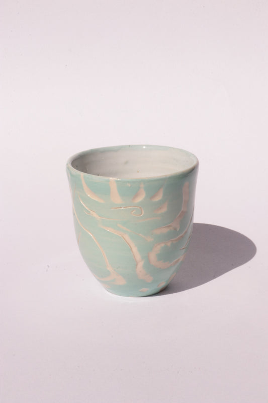 engraved light blue ceramic cup on white background