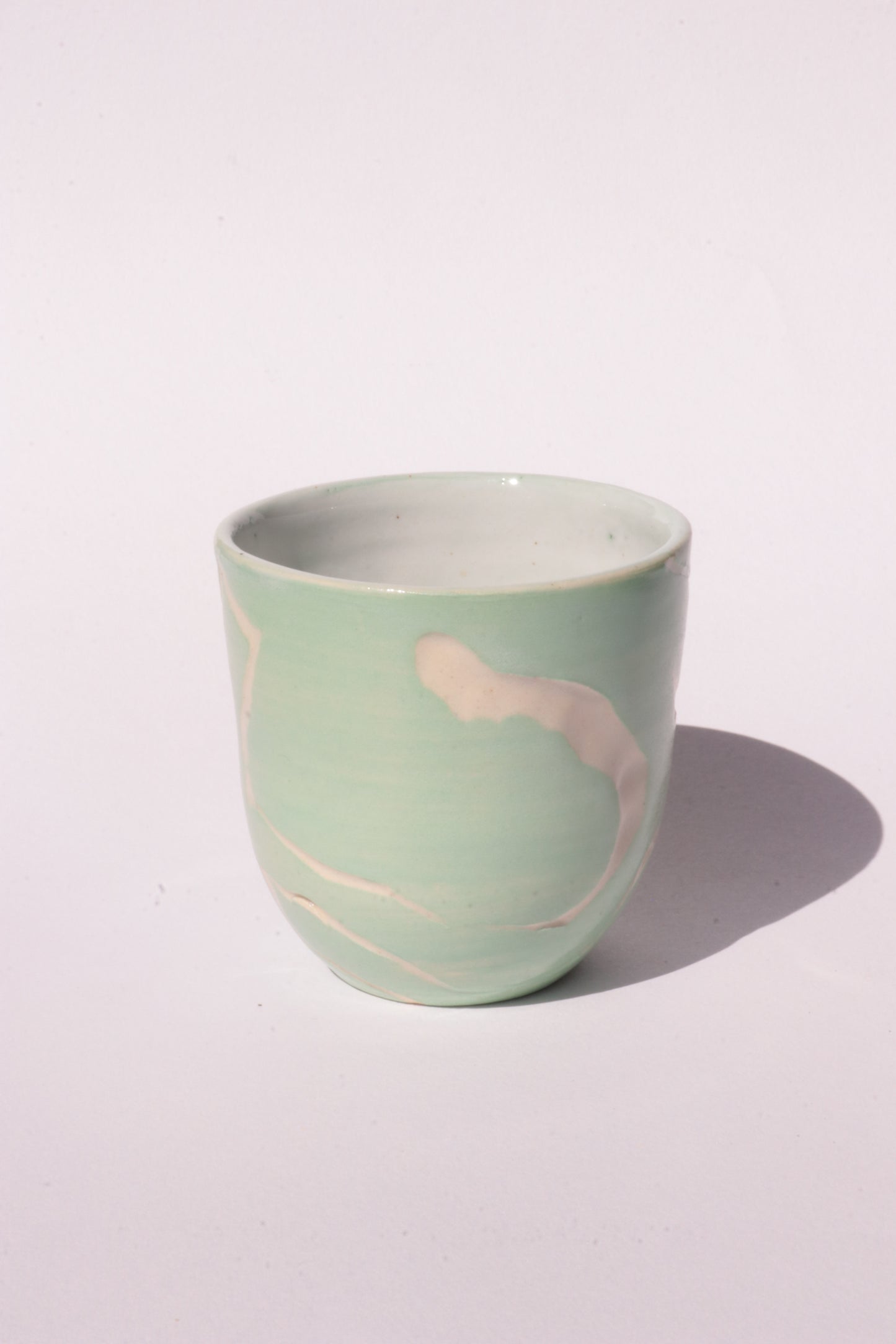 engraved light blue ceramic cup on white background