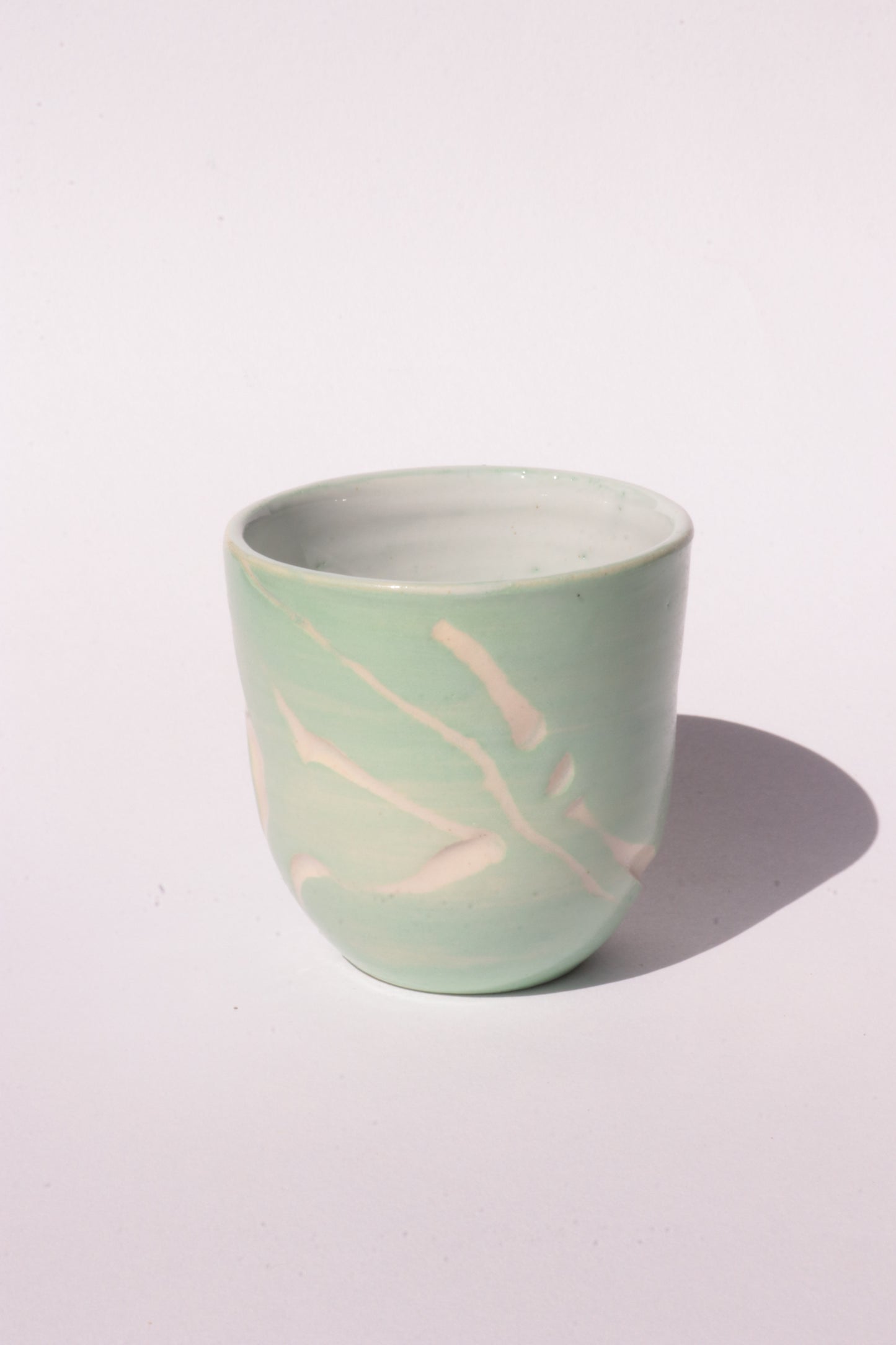 engraved light blue ceramic cup on white background