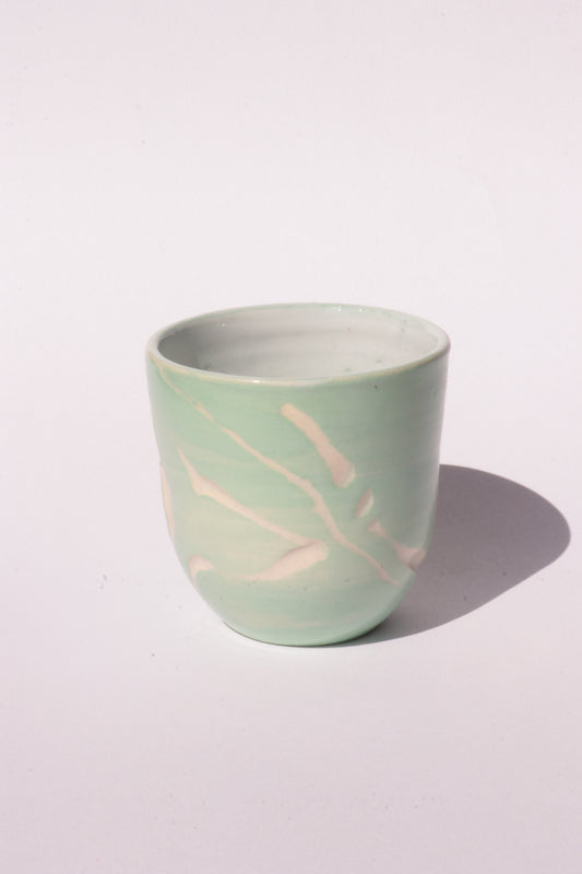 engraved light blue ceramic cup on white background