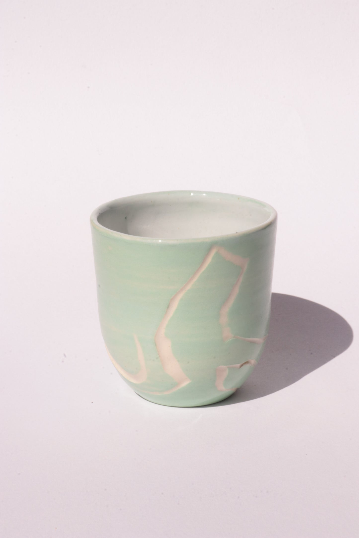 engraved light blue ceramic cup on white background
