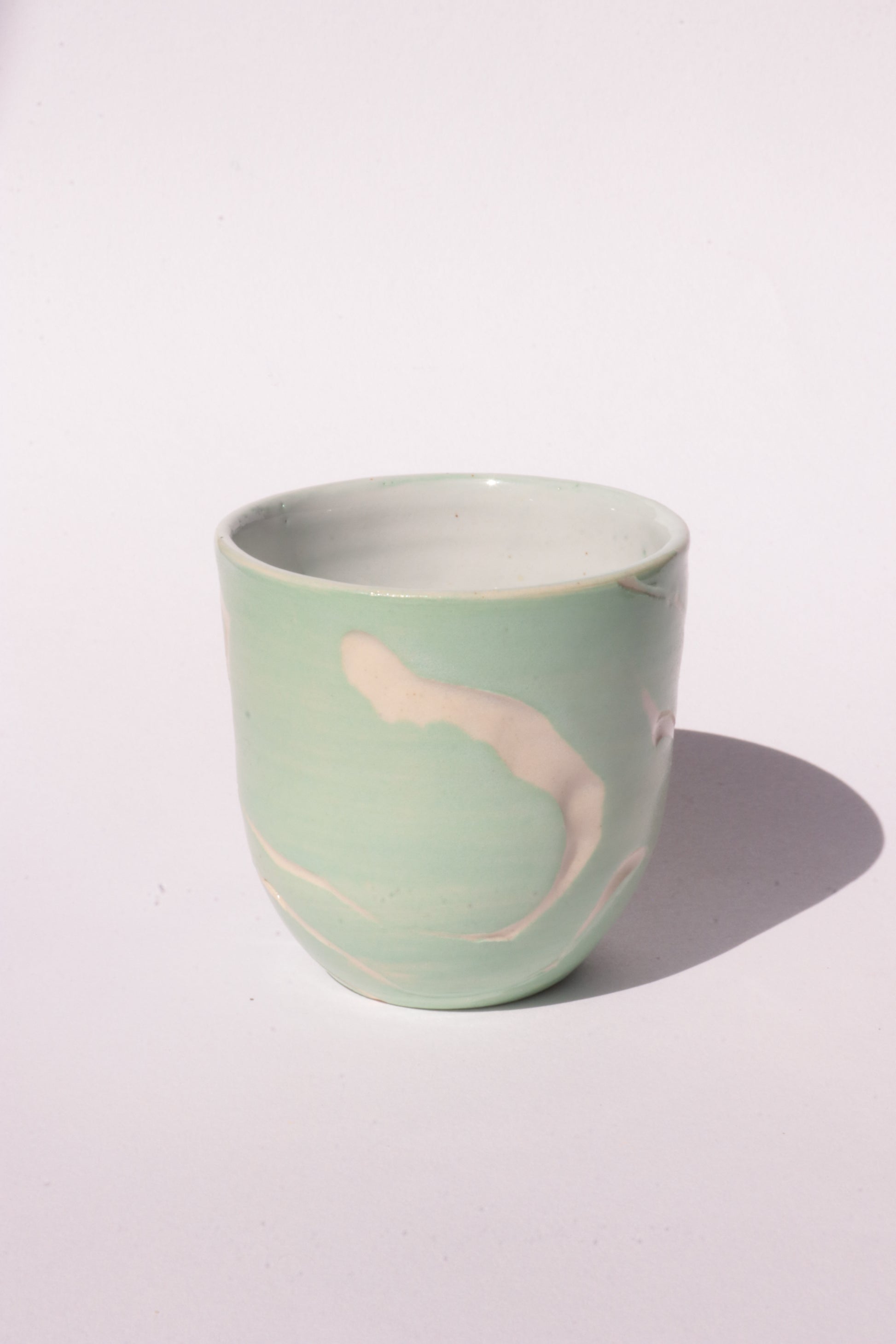 engraved light blue ceramic cup on white background