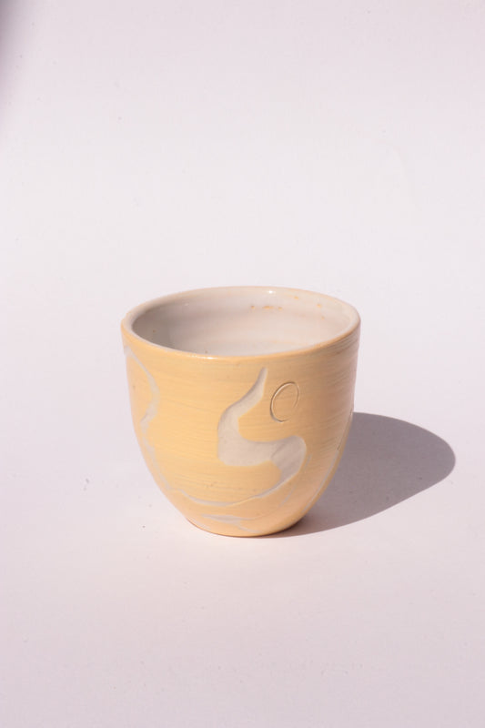 engraved yellow ceramic cup on white background
