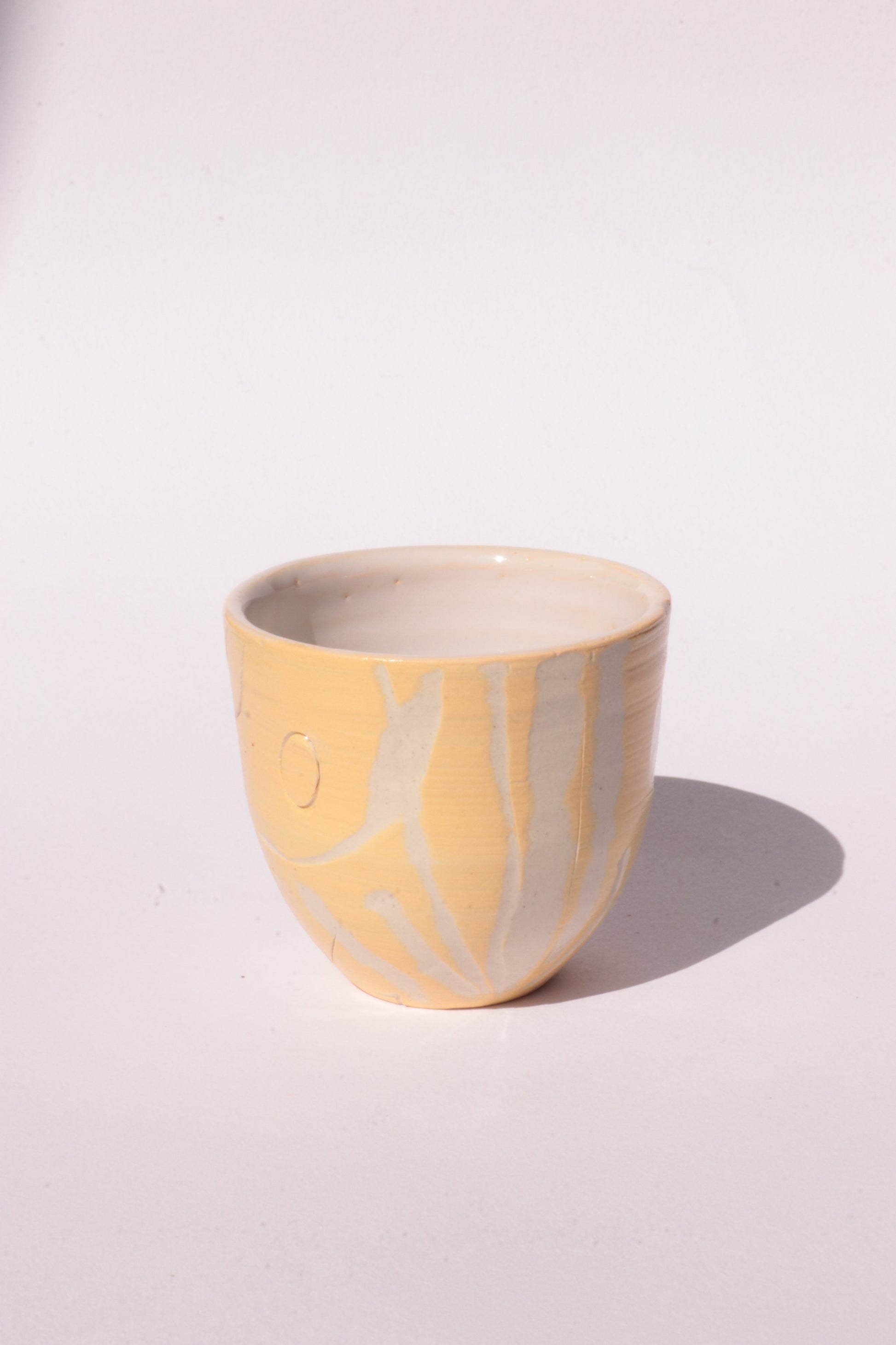 engraved yellow ceramic cup on white background