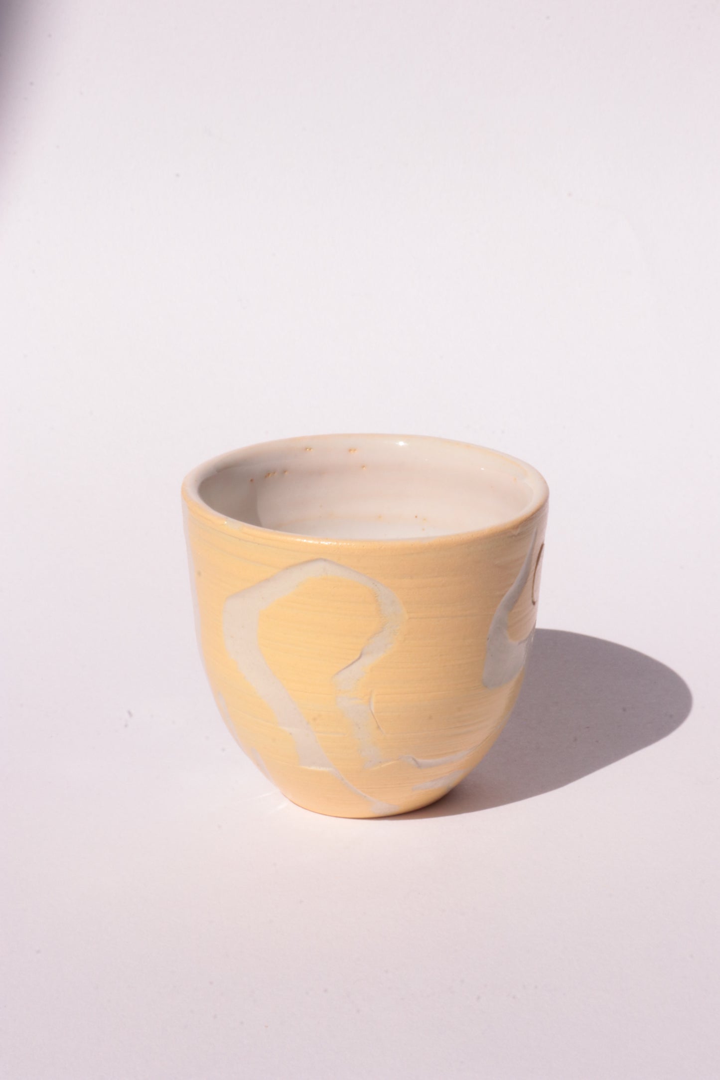 engraved yellow ceramic cup on white background