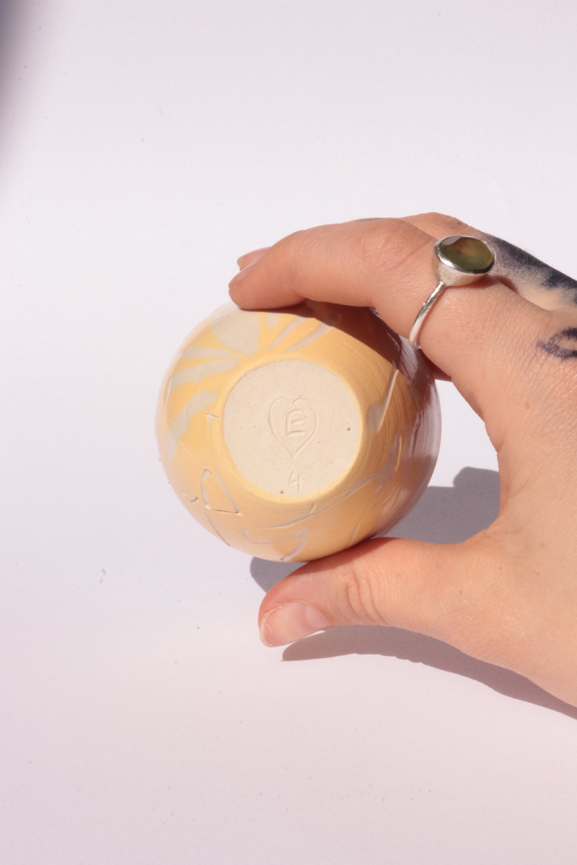 engraved yellow ceramic cup on white background