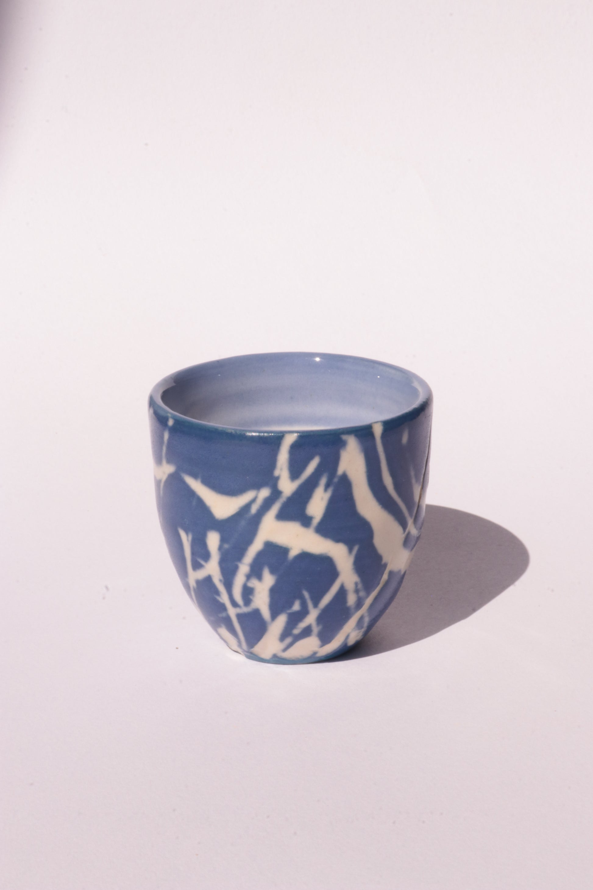 engraved dark blue ceramic cup on white background