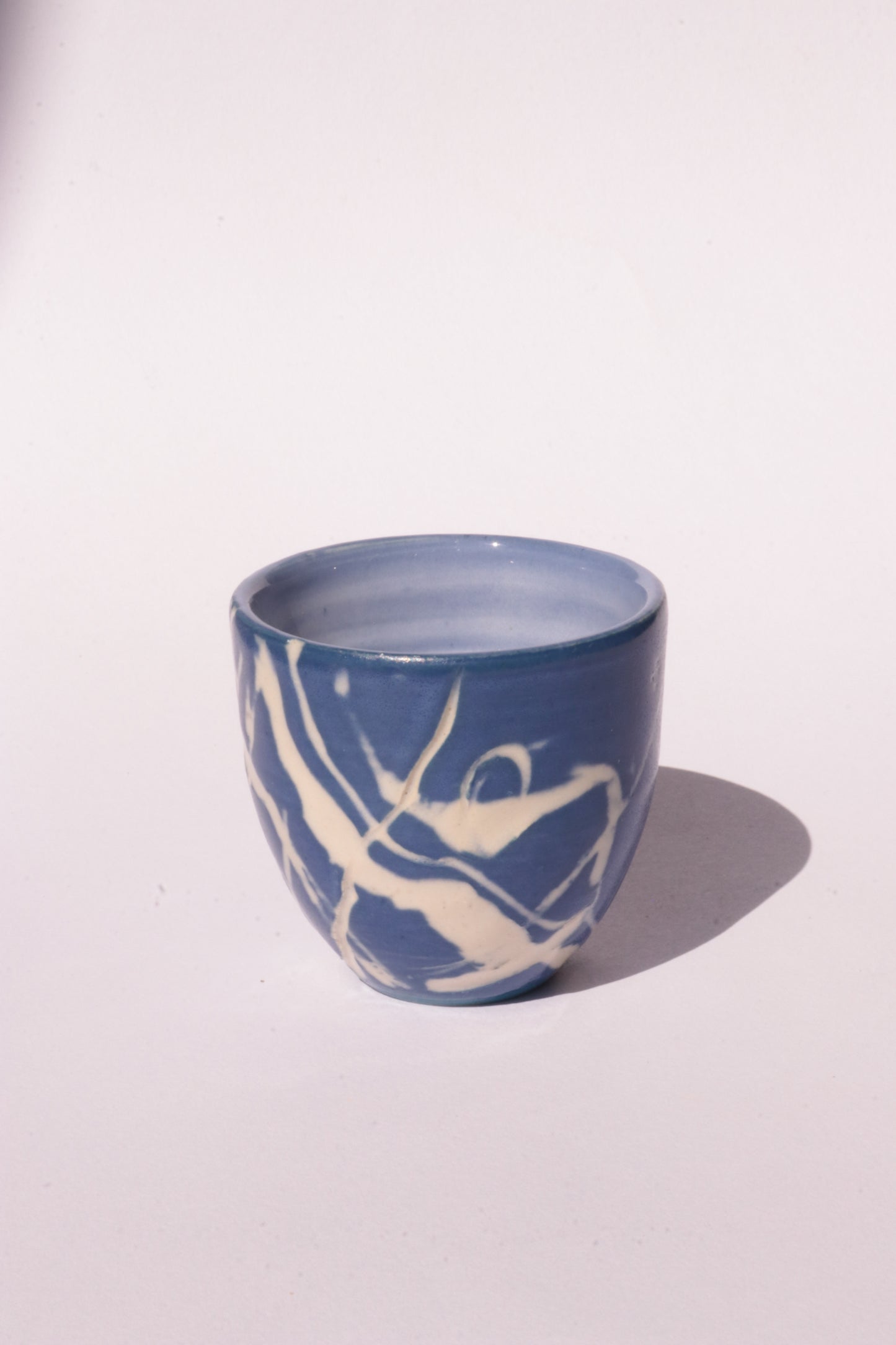 engraved dark blue ceramic cup on white background