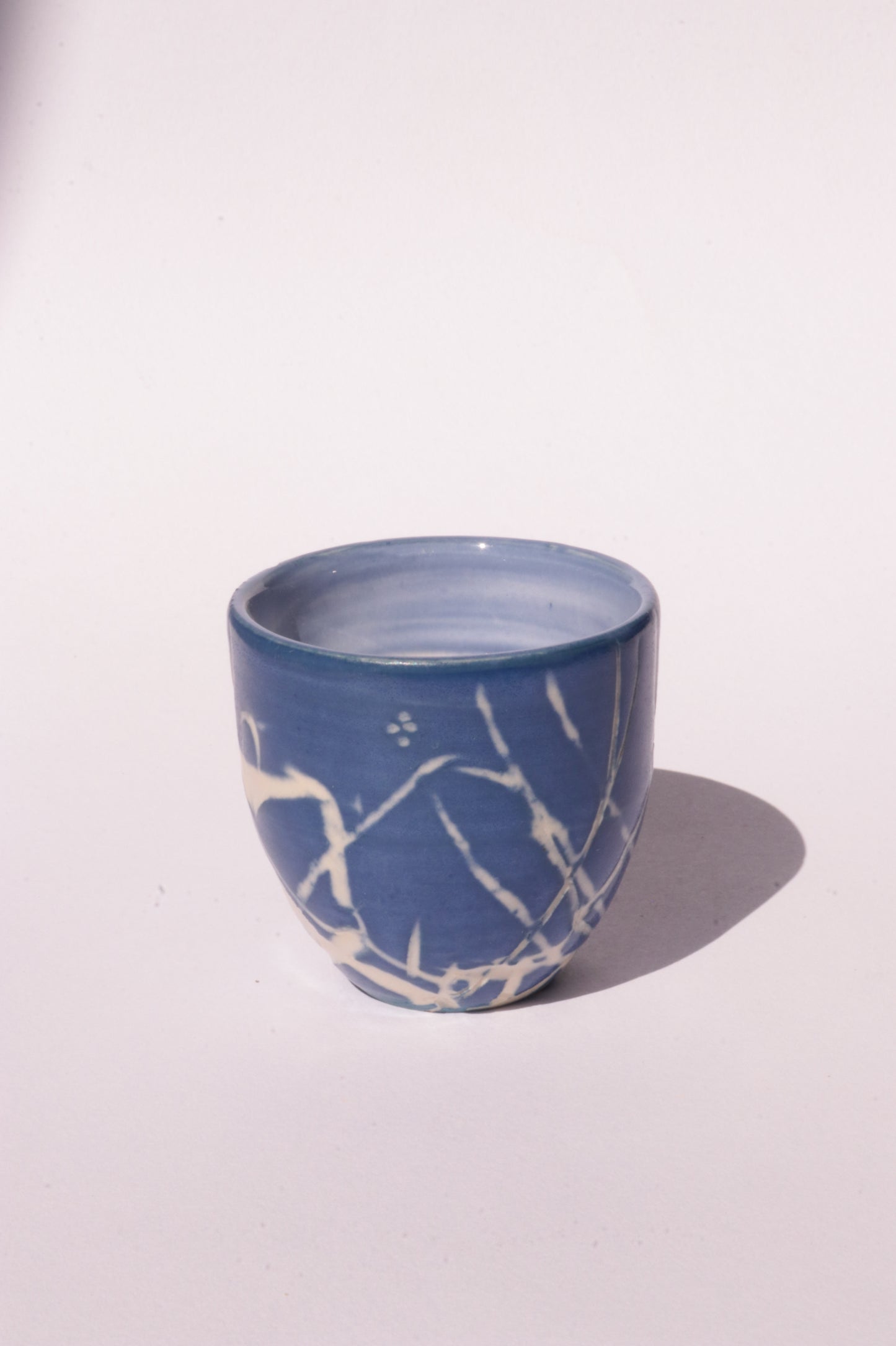 engraved dark blue ceramic cup on white background