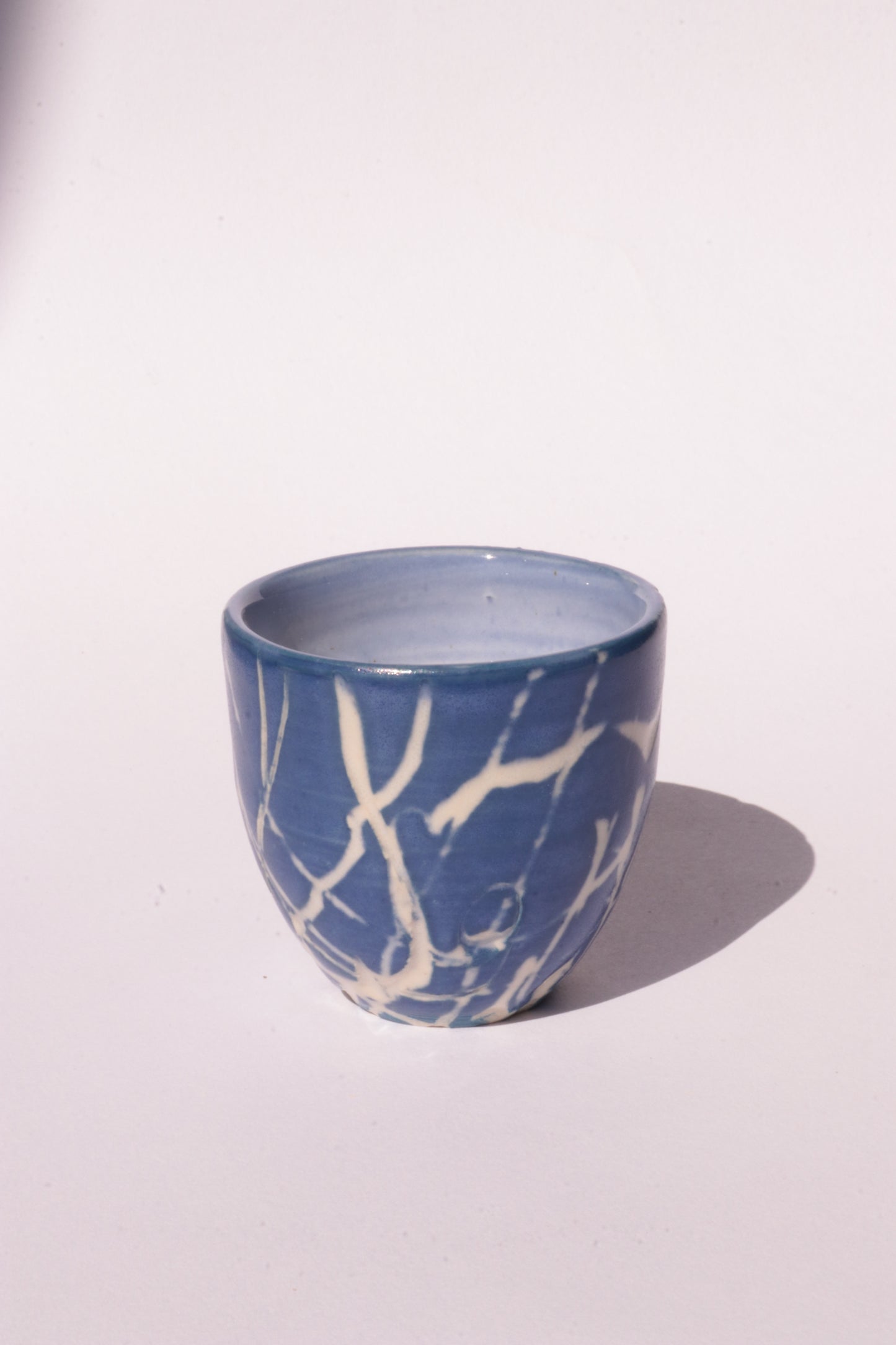 engraved dark blue ceramic cup on white background
