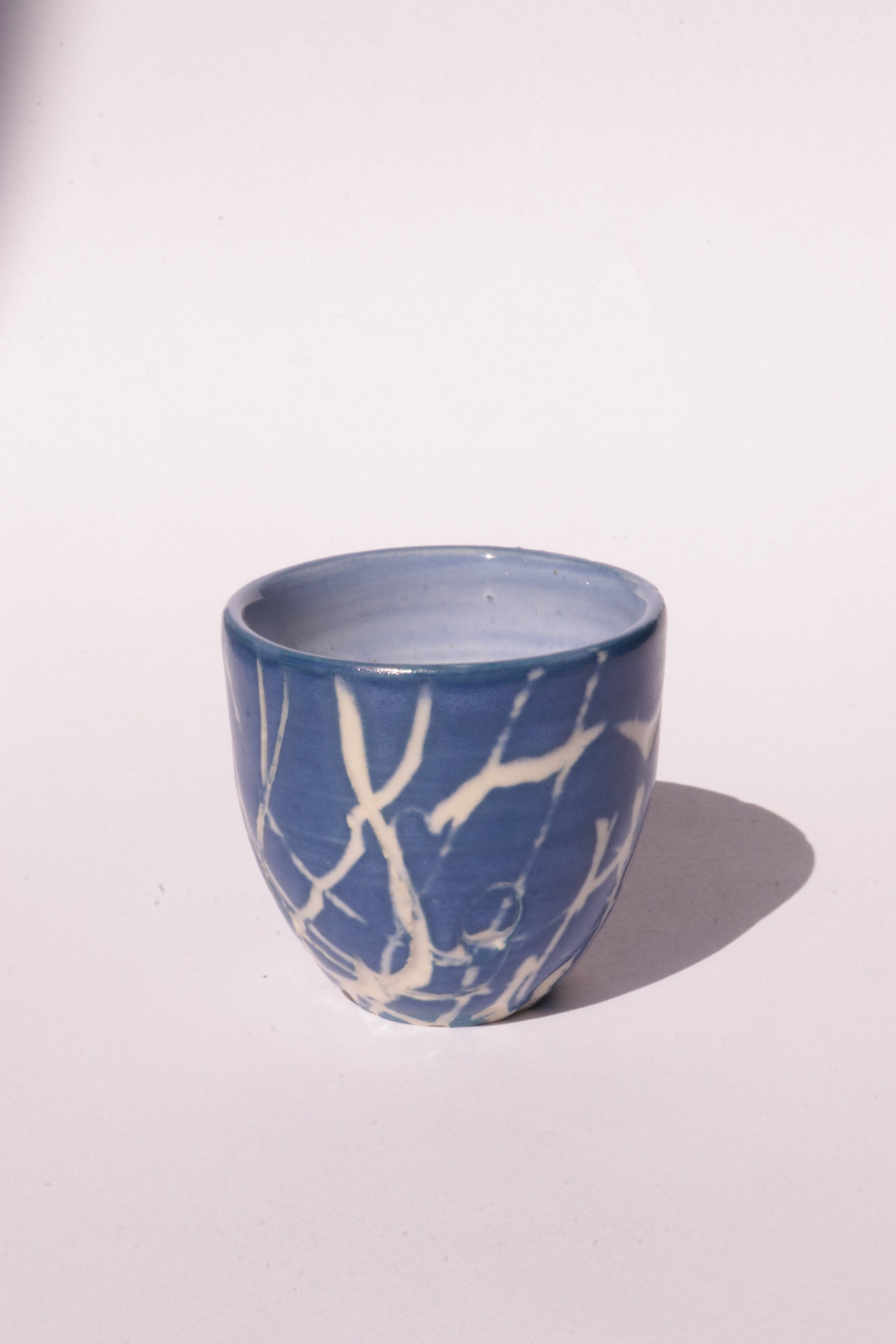 engraved dark blue ceramic cup on white background