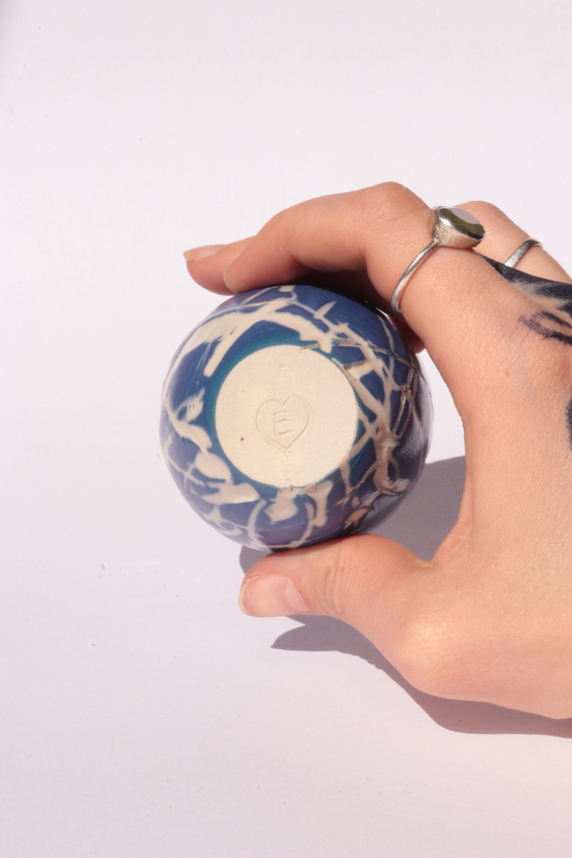 engraved dark blue ceramic cup on white background