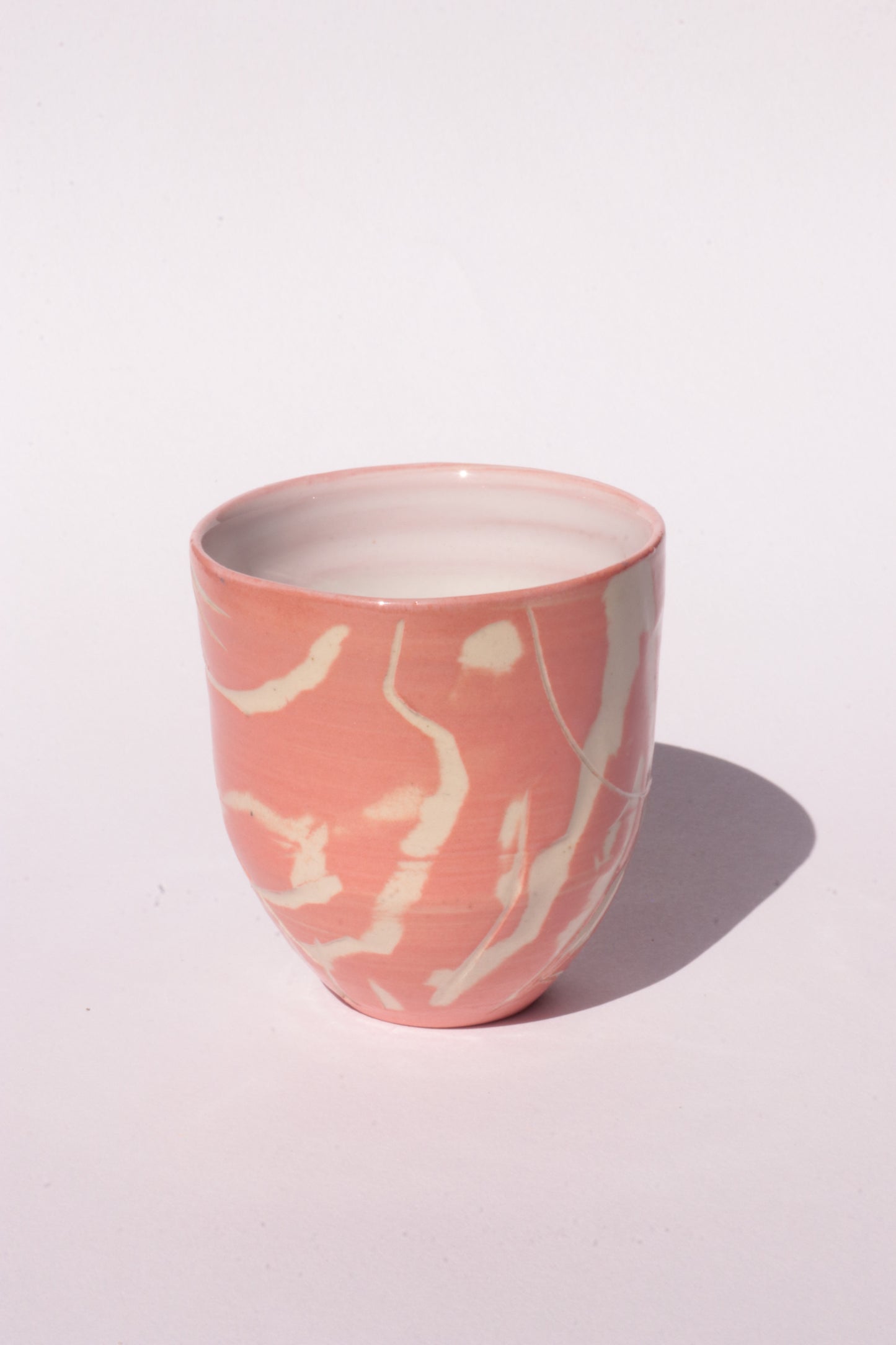 engraved orange ceramic cup on white background