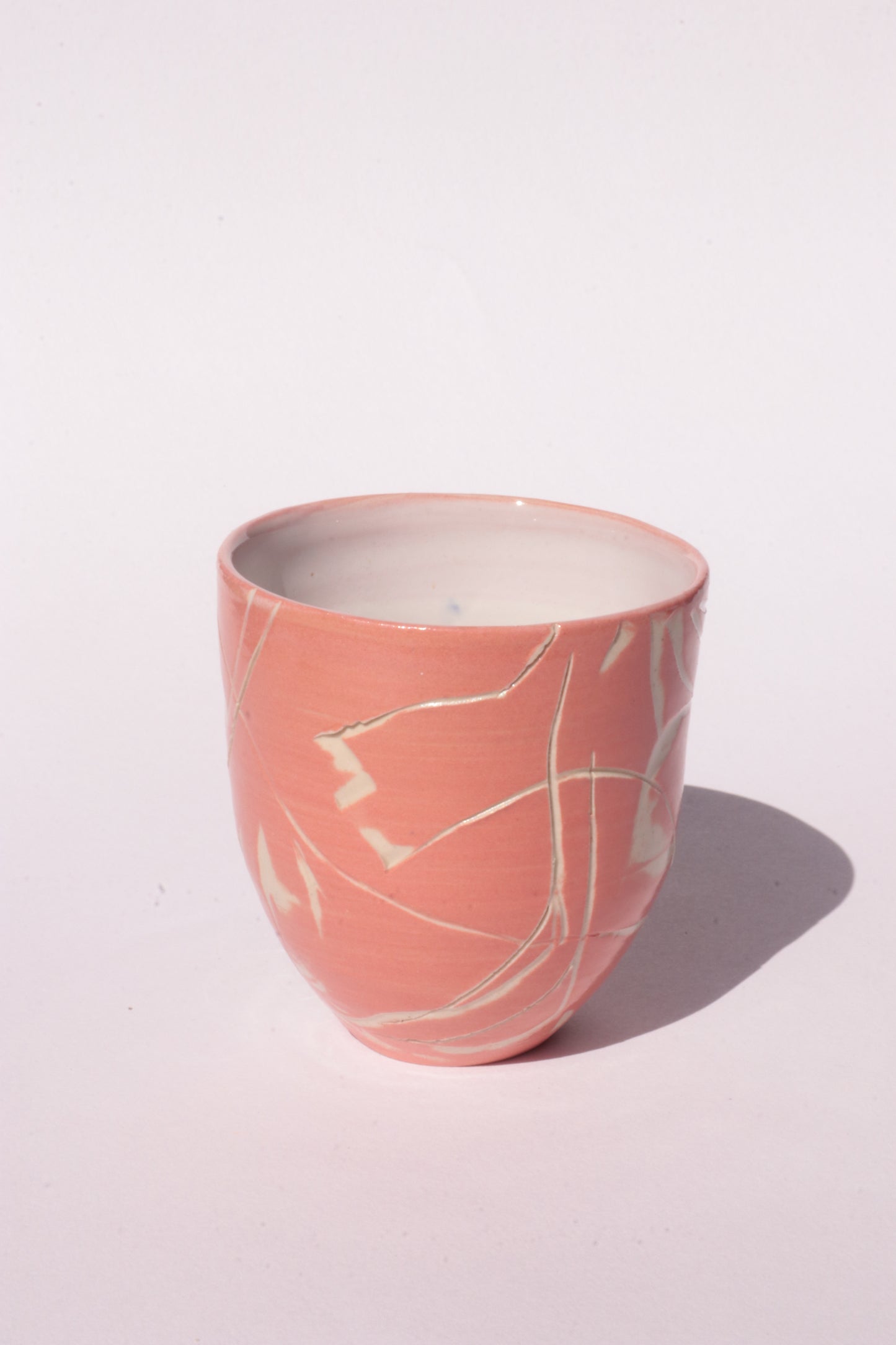 engraved orange ceramic cup on white background