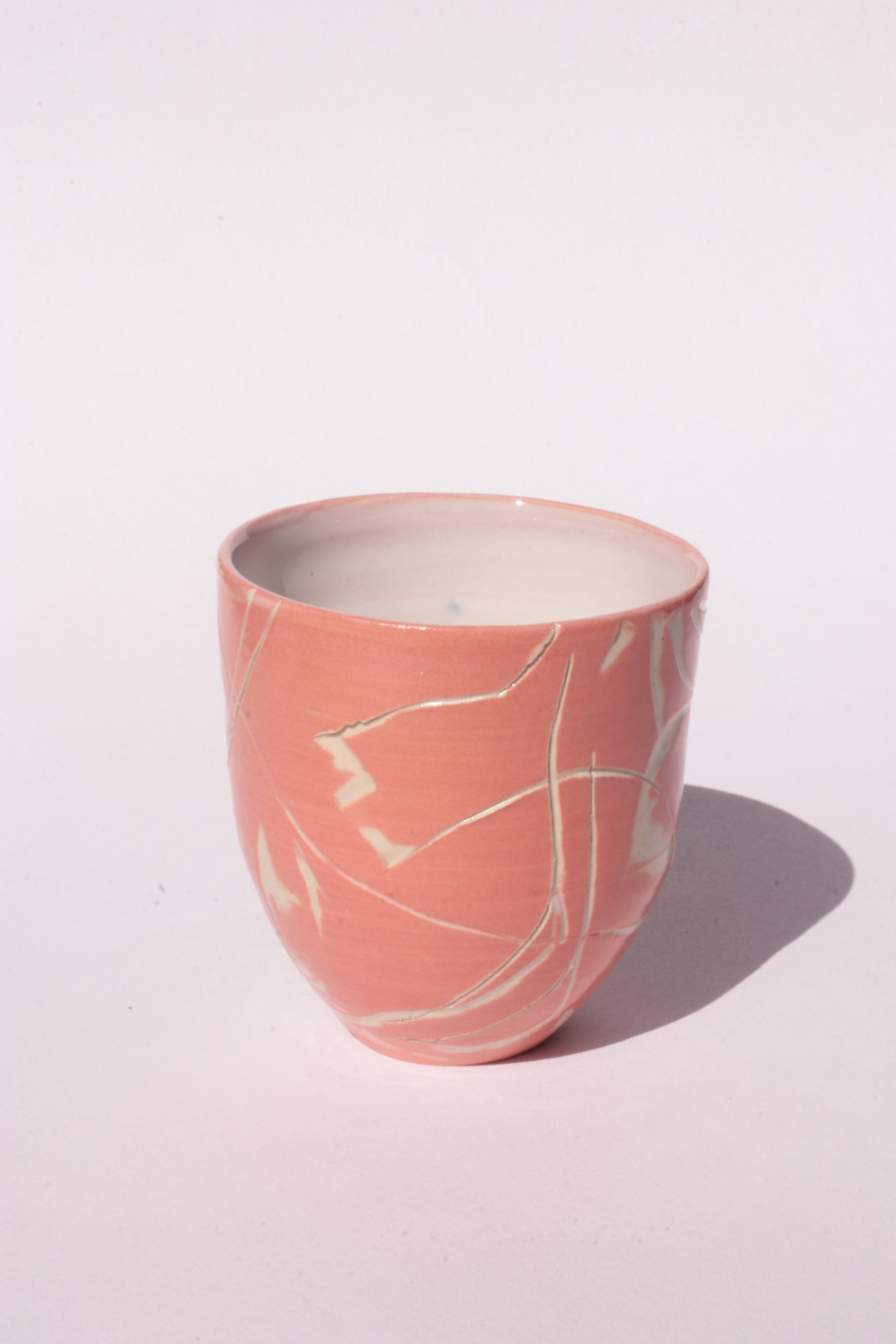 engraved orange ceramic cup on white background