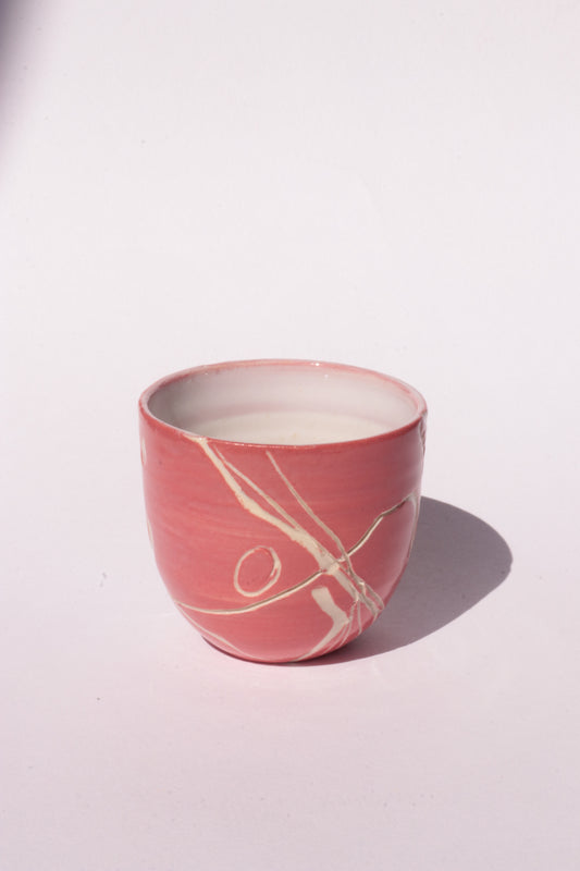 engraved magenta ceramic cup on white background
