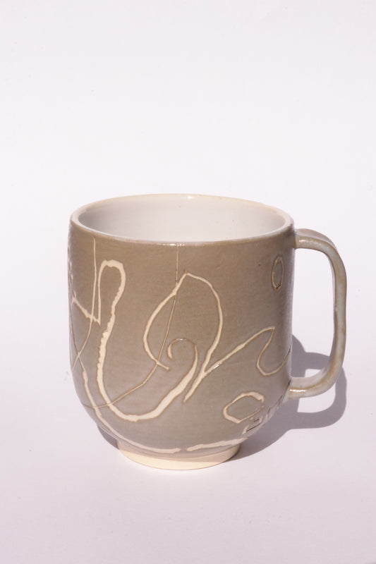 Brown mug with engraved white abstract design on a white background