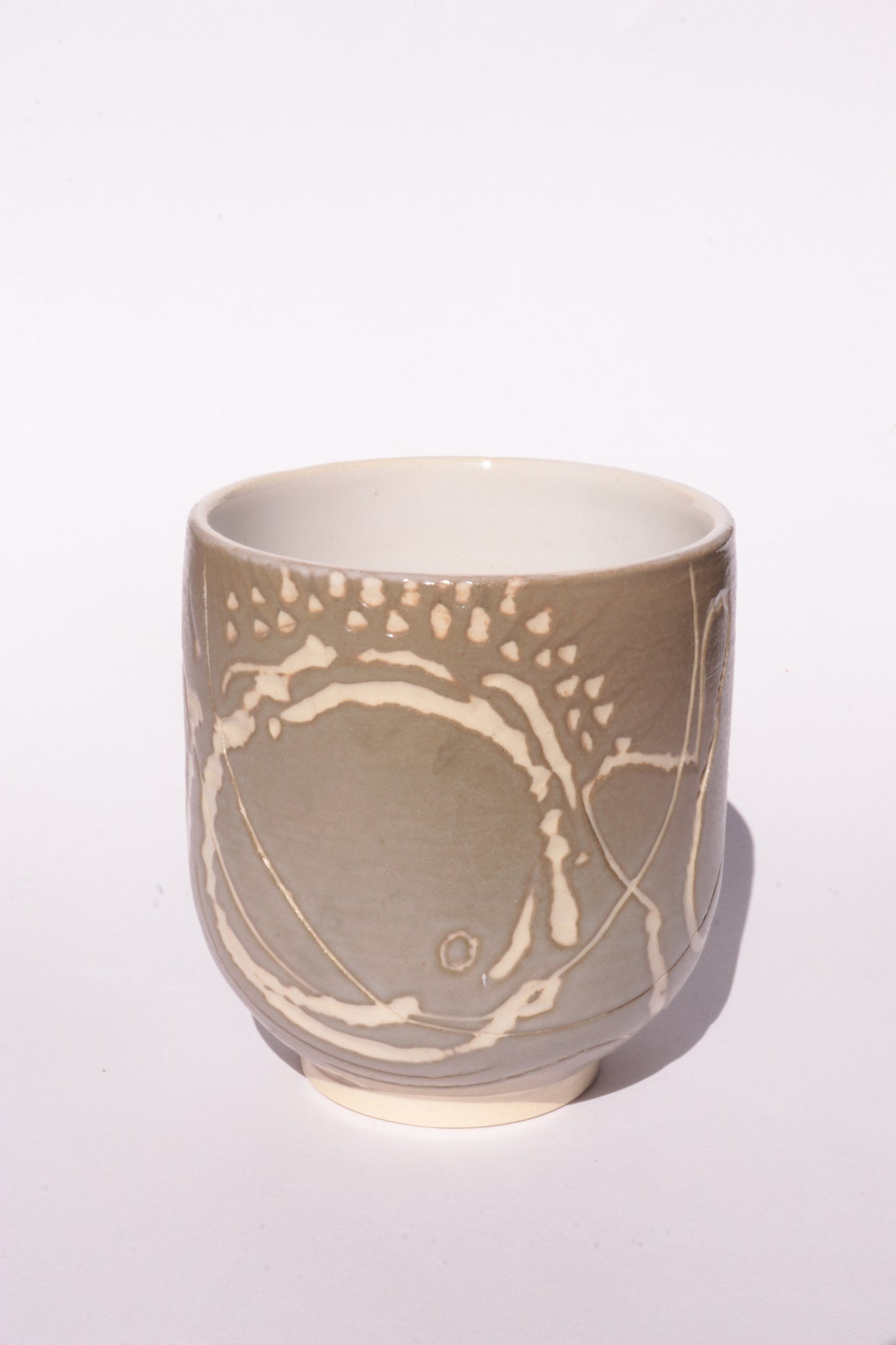 Brown mug with engraved white abstract design on a white background