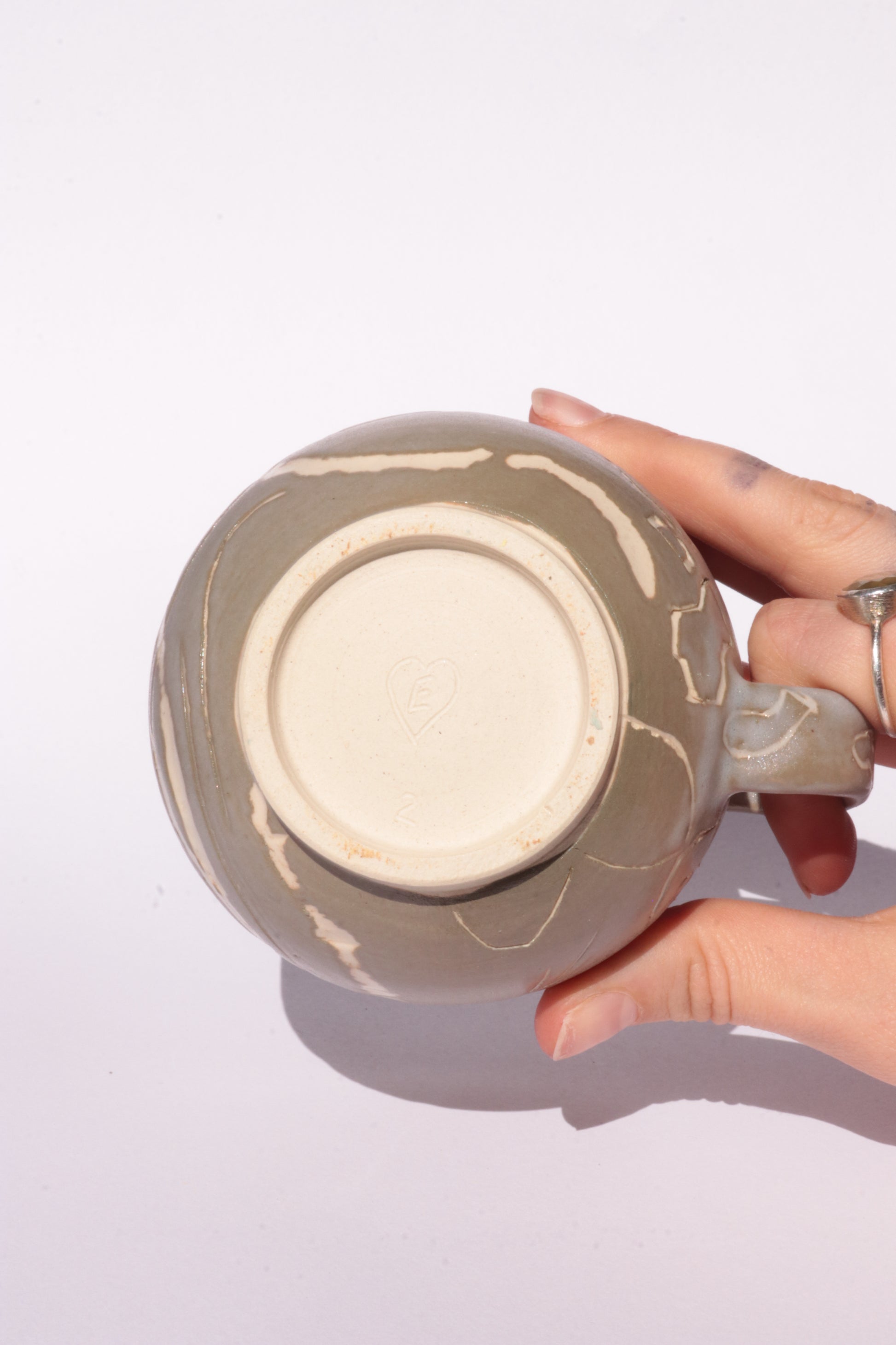 Brown mug with engraved white abstract design on a white background