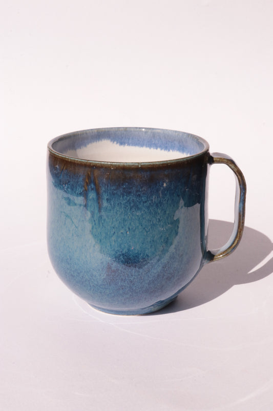 Dark blue mug with subtle engraved design on a white background