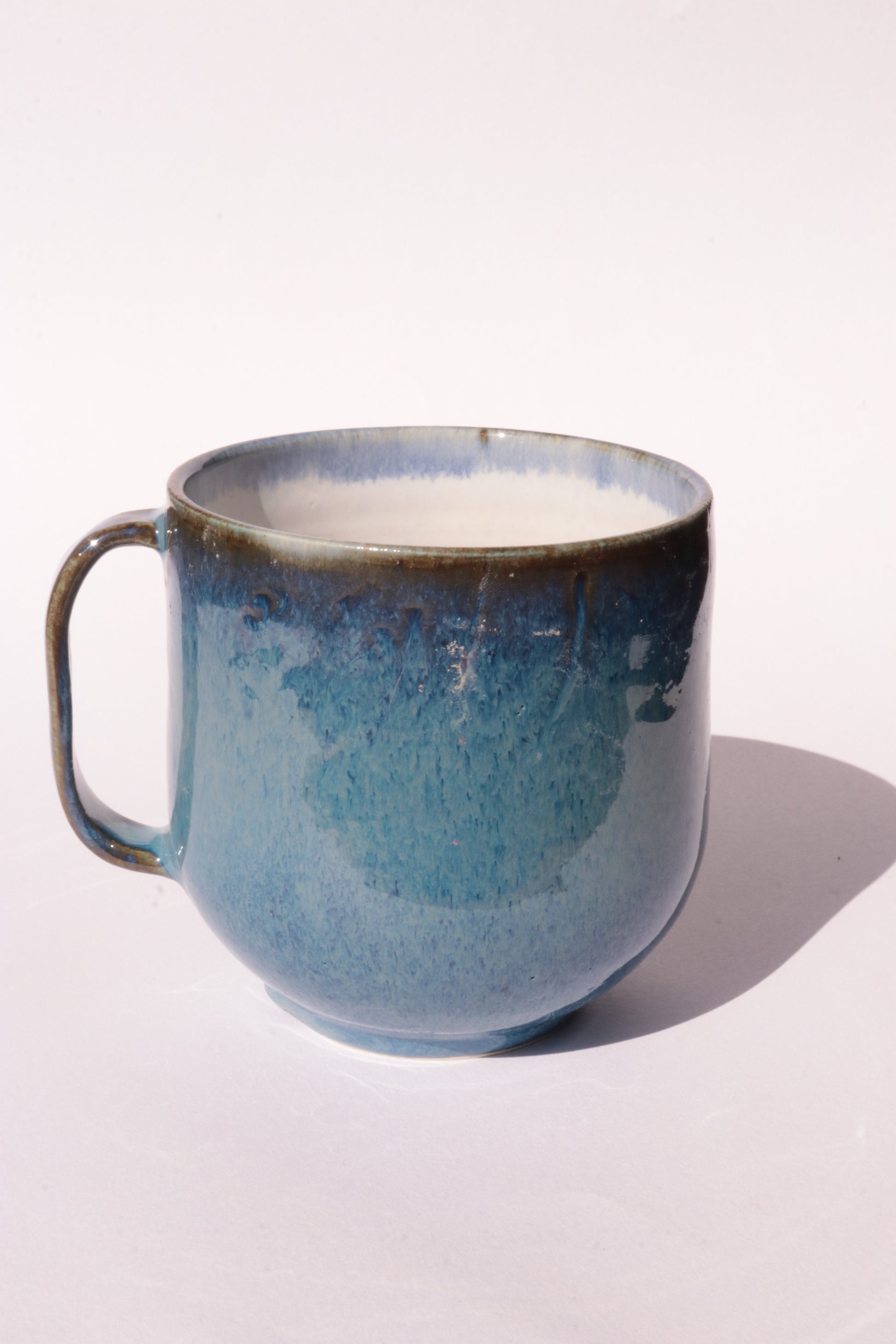 Dark blue mug with subtle engraved design on a white background
